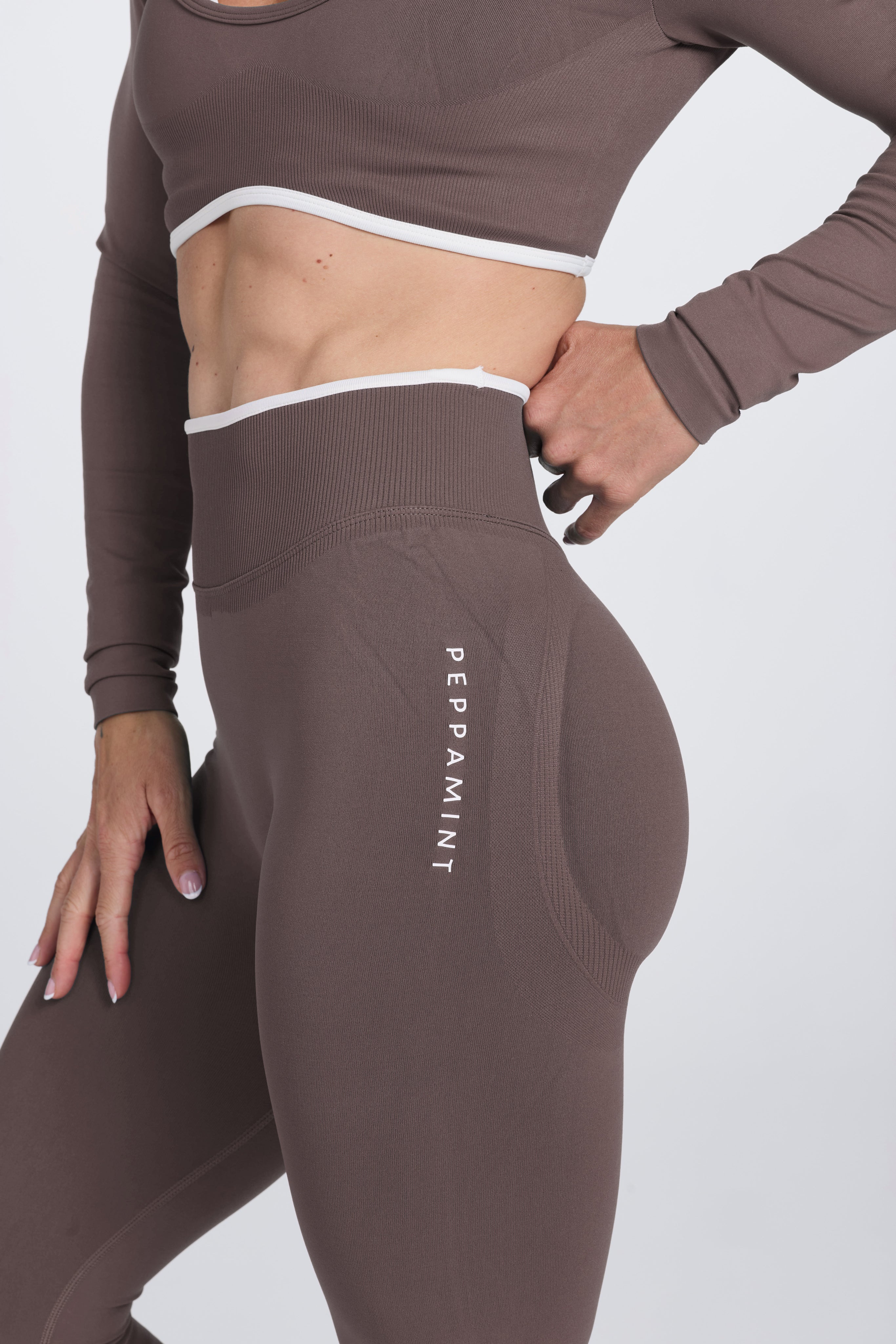 High waisted booty sculpting gym tights, with textured contouring panels and a luxe white trim with PEPPAMINT branded down the upper thigh in Mocha colour.