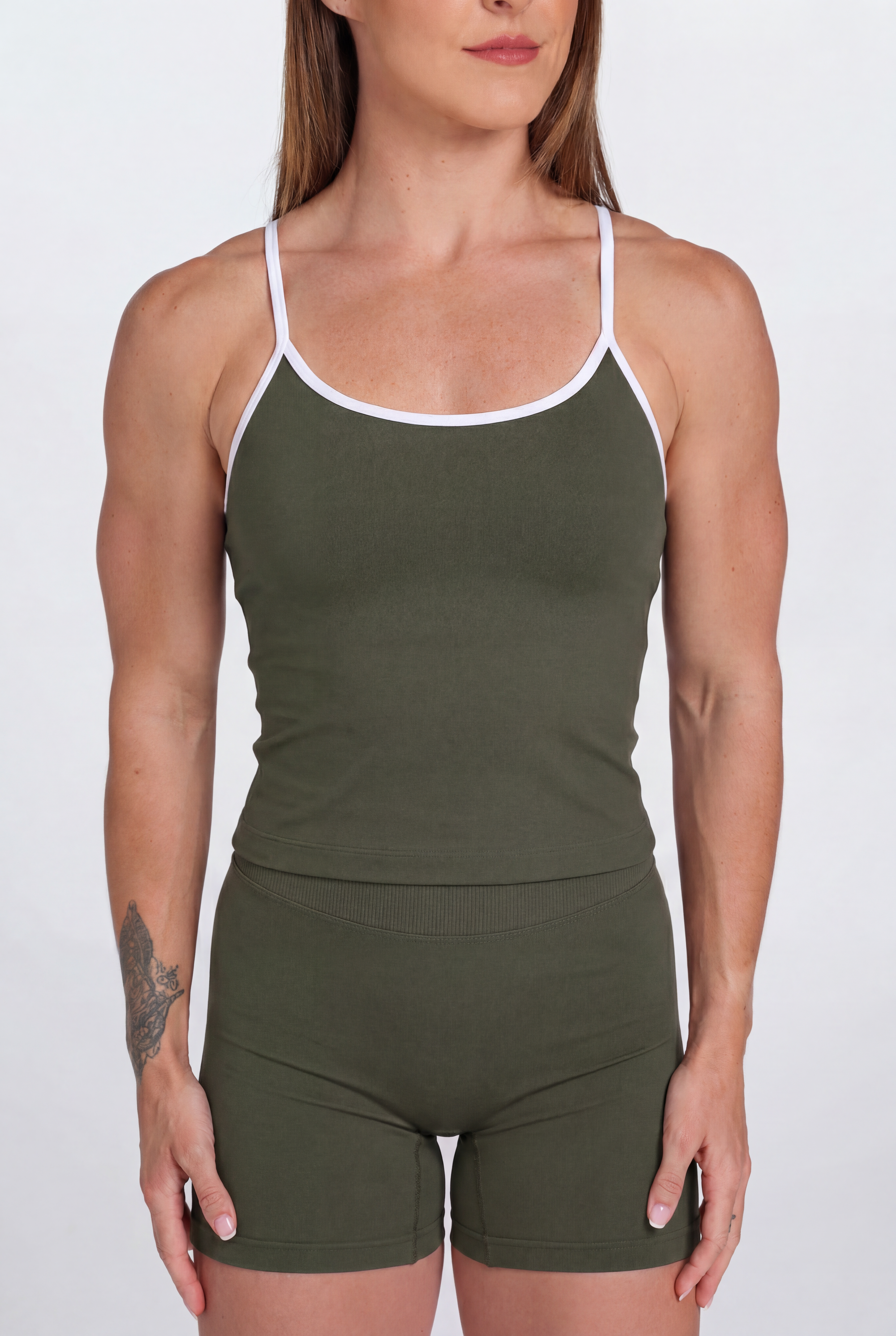 Woman wearing an Army Green tank top and shorts set with white trim on a white background