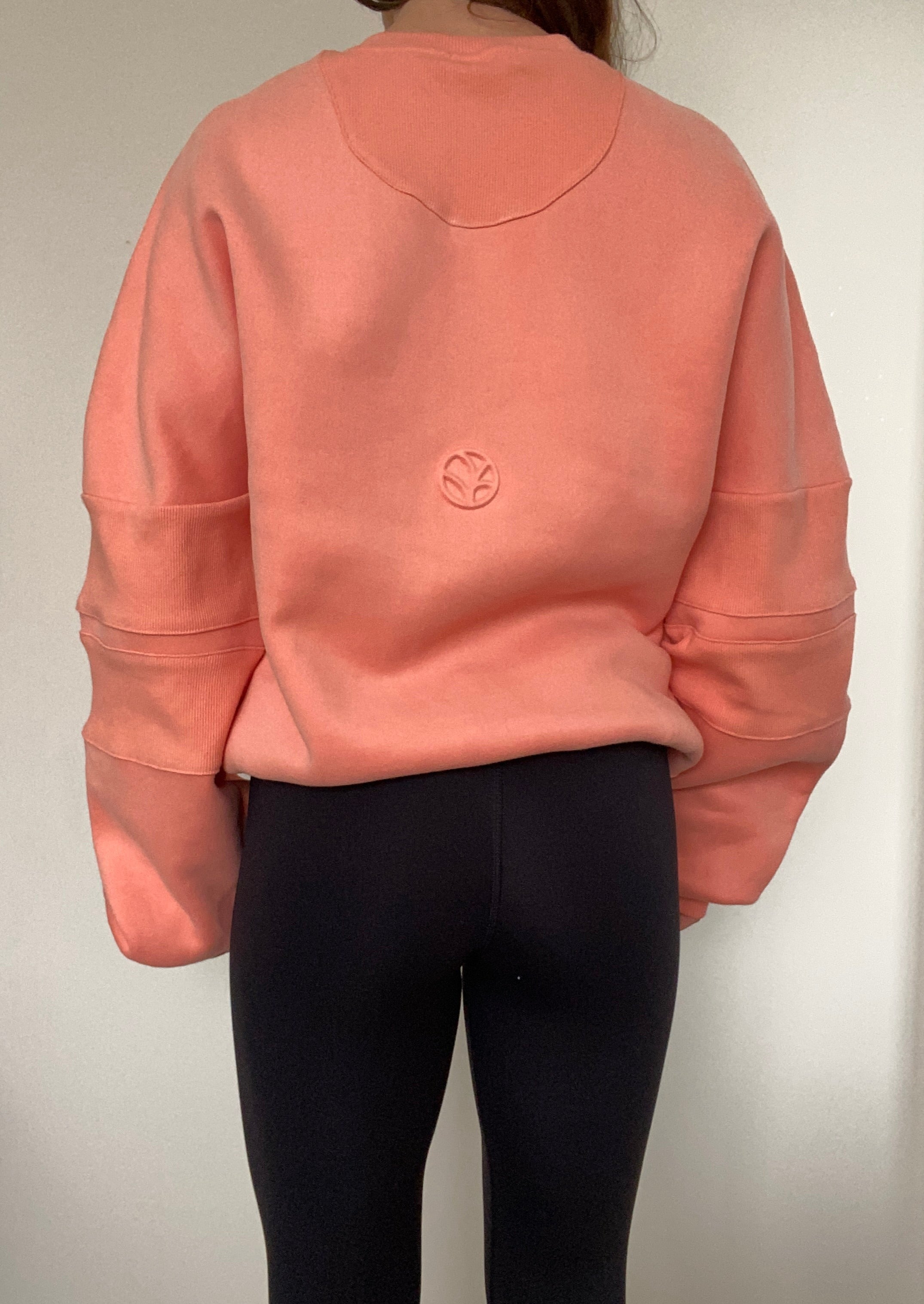 crew neck jumper in coral with embossed chest logo and ribbed panels on sleeves