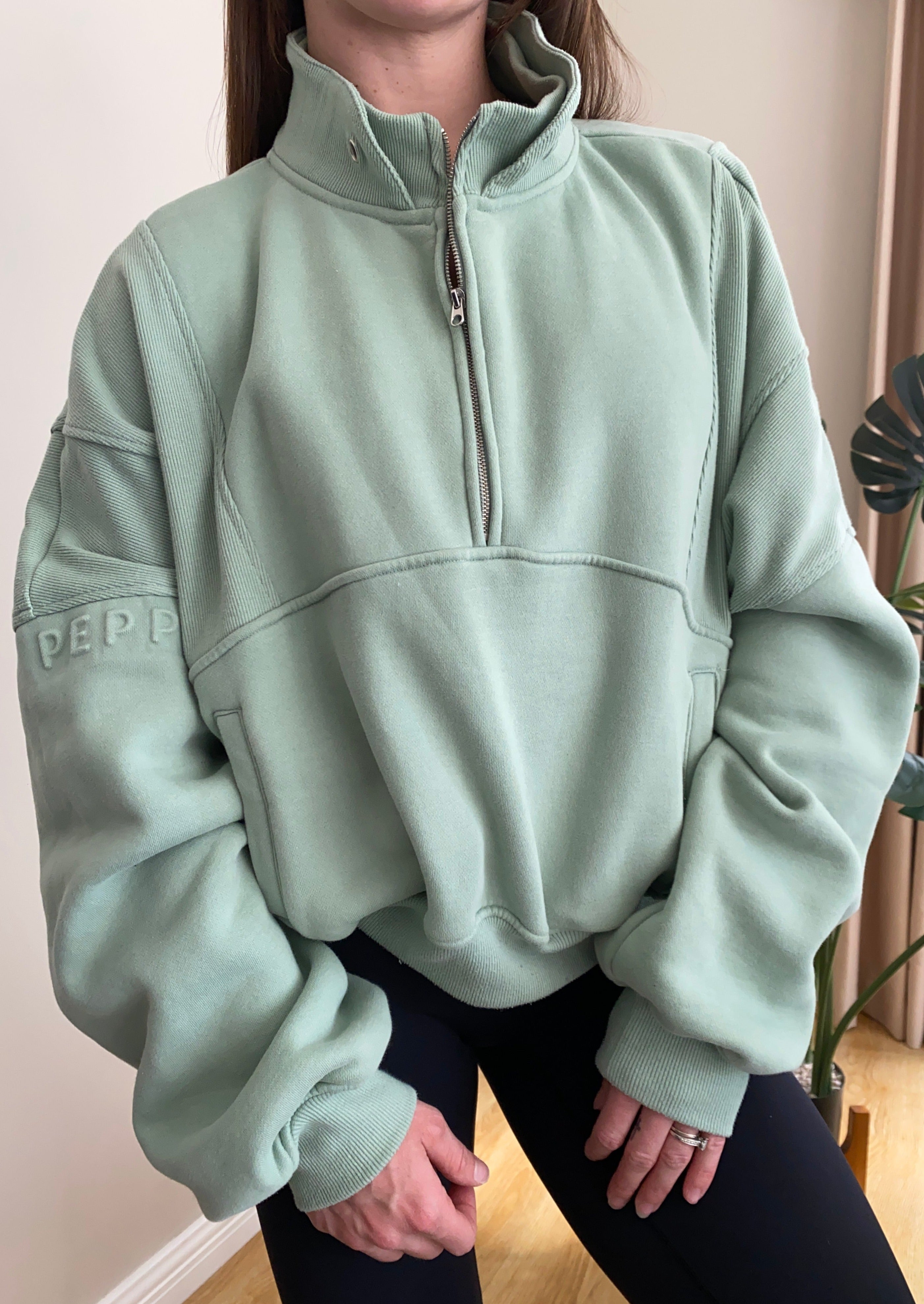 Fleece lined crop jacket in light green with half zip, and ribbed panels, and side pockets.