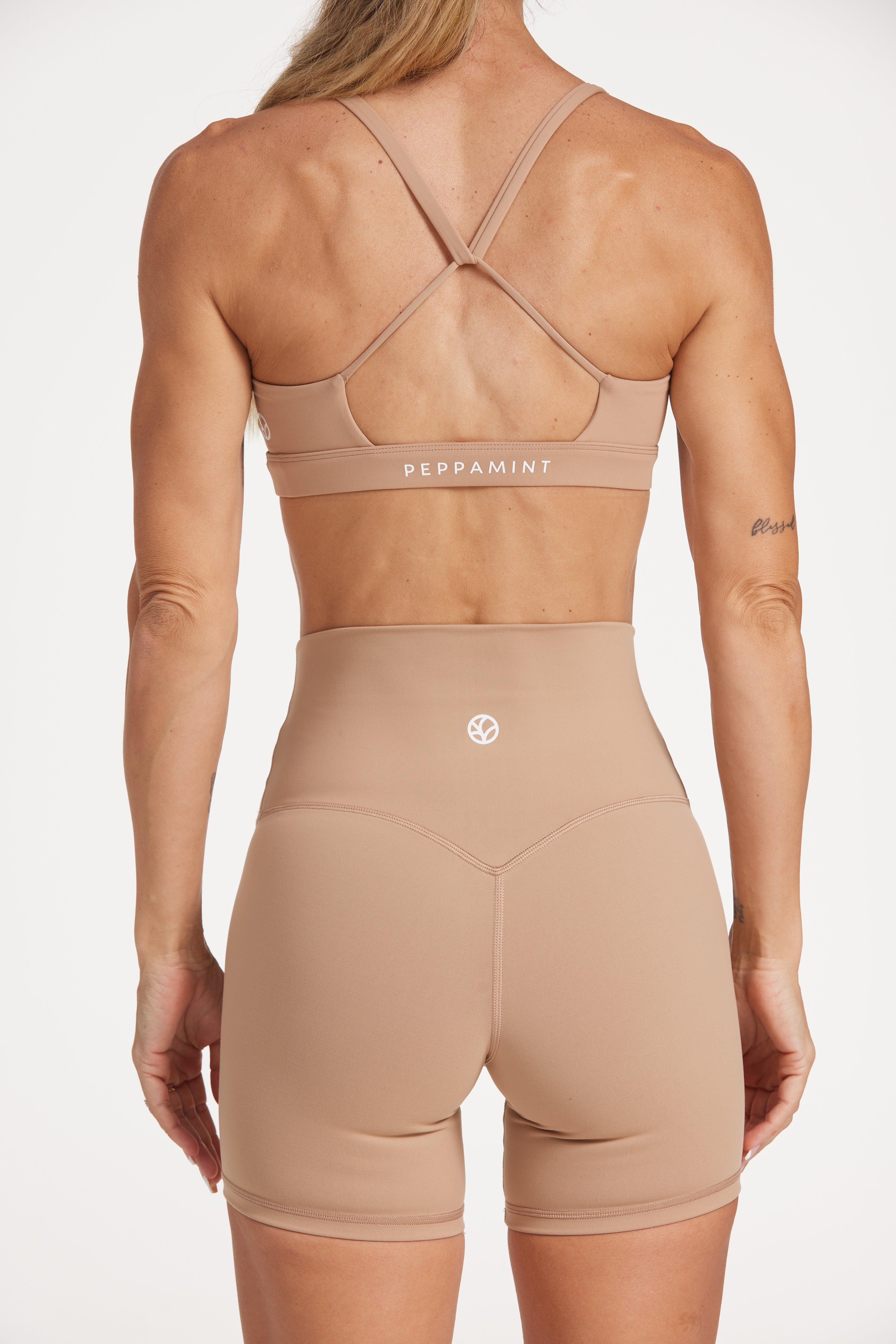 high waisted gym shorts, in buttery soft, supportive fabric with 6 inch inseam and no front rise seam, in a light taupe colour with women's moderate support activewear bra in buttery soft fabric with stunning triangle open back detail and scoop neckline
