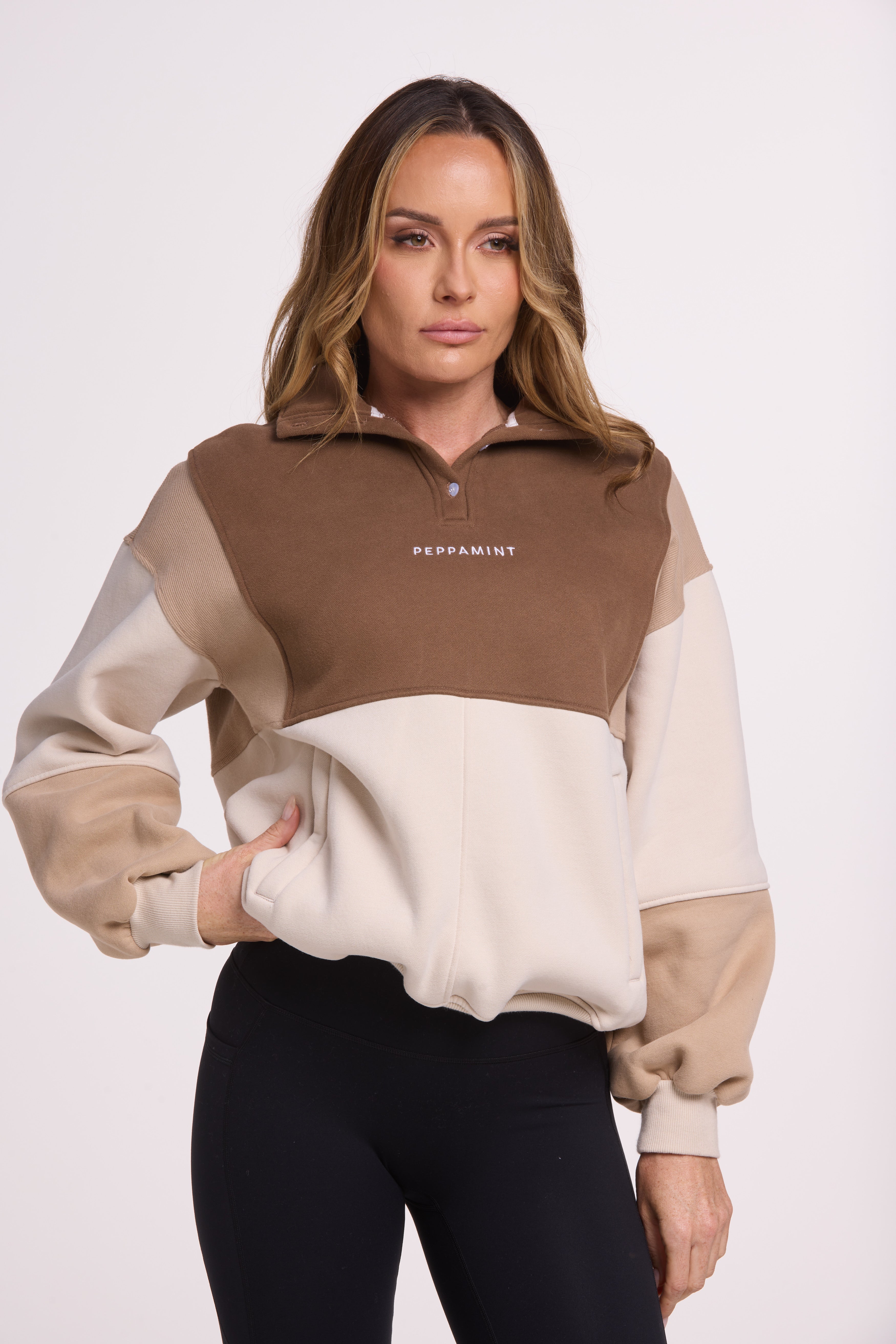 1/4 button up fleece jumper with earthy colour panels in chocolate and beige, with feature panels ribbed stretchy fabric inserts, and two convenient zip pockets.