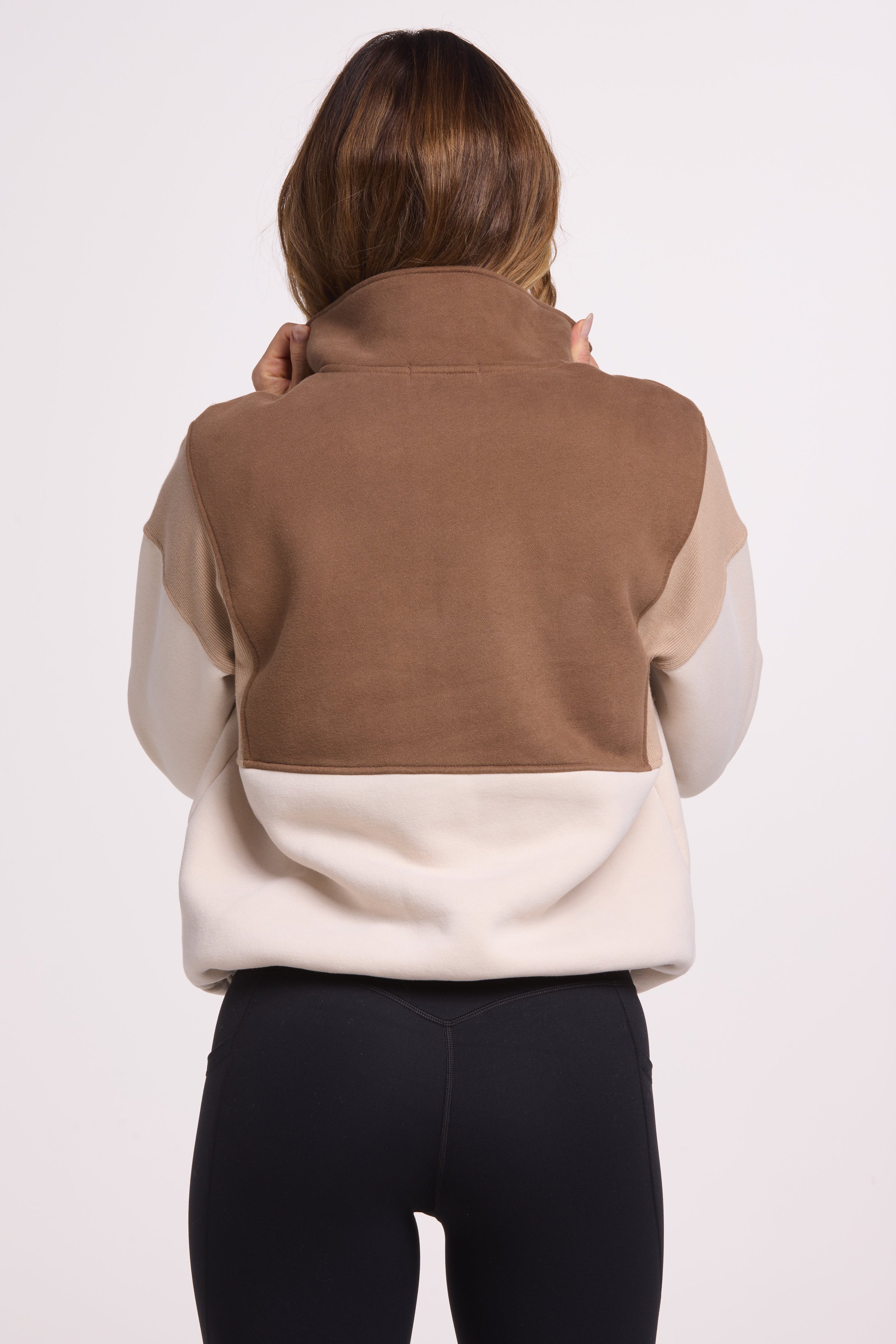 1/4 button up fleece jumper with earthy colour panels in chocolate and beige, with feature panels ribbed stretchy fabric inserts, and two convenient zip pockets.