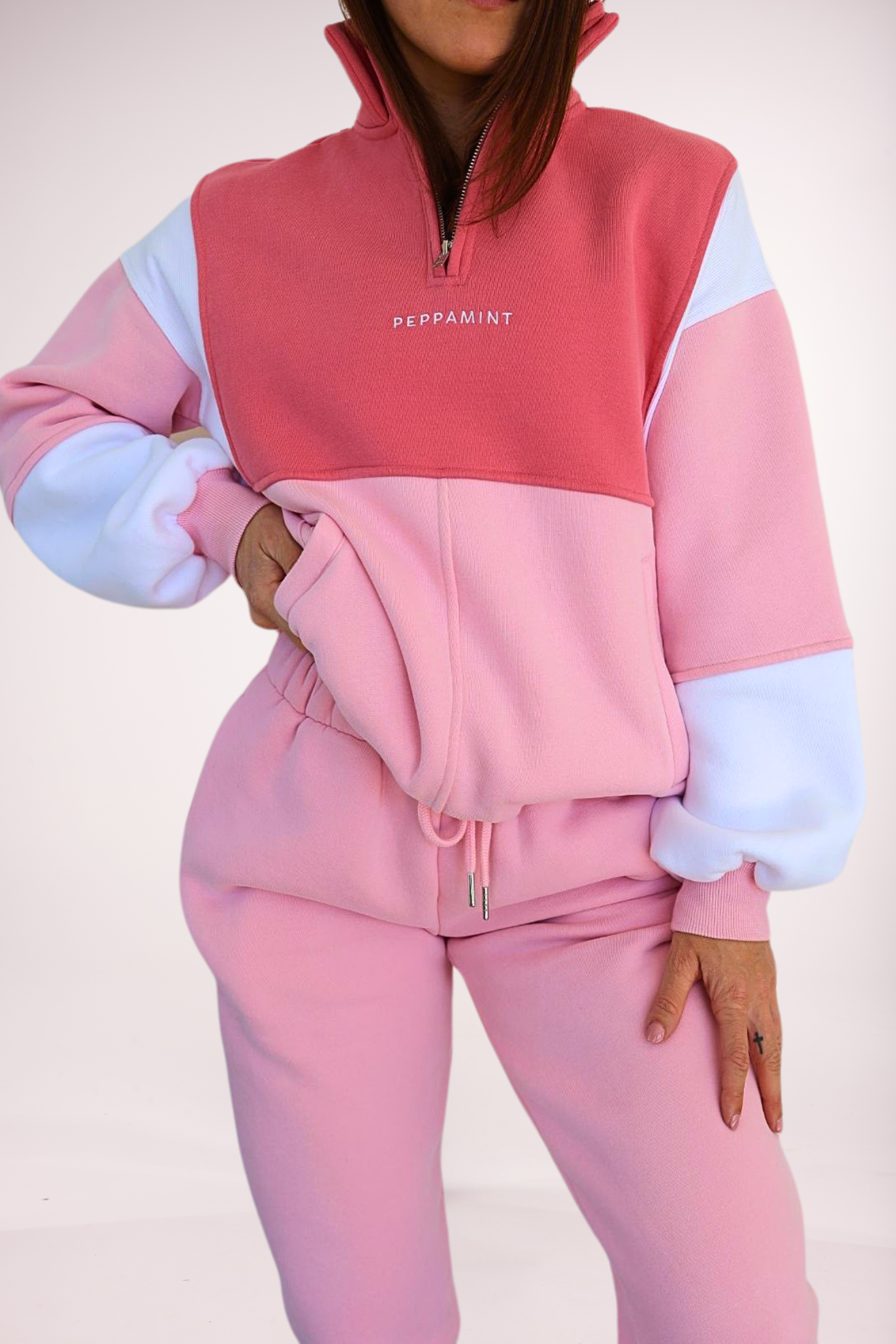 1/4 zip fleece jumper with double collar, in peony pink/white and baby pink colour panels, with feature panels ribbed stretchy fabric inserts, and two convenient zip pockets paired with fleece lined joggers with elasticated waistband, drawstring and embossed logo icon on pocket