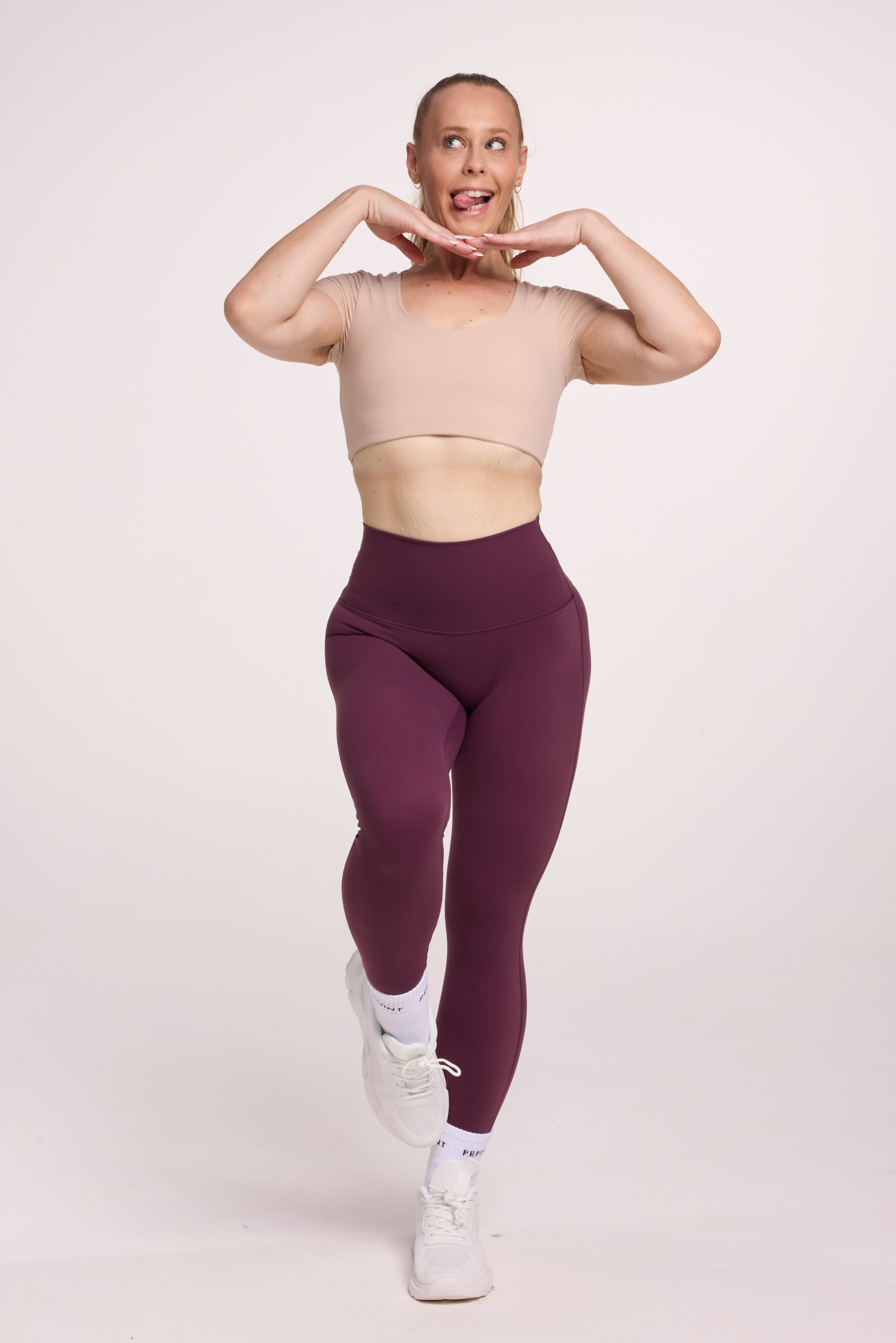Buttery soft high waisted women's gym tights with curved back seam stitched detailing for a butt shaping effect, and no front rise seam, in plum purple paired with an V neck women's crop t-shirt with a supportive elasticated hem and triple layered fabric with removable pads for extra support in
beige