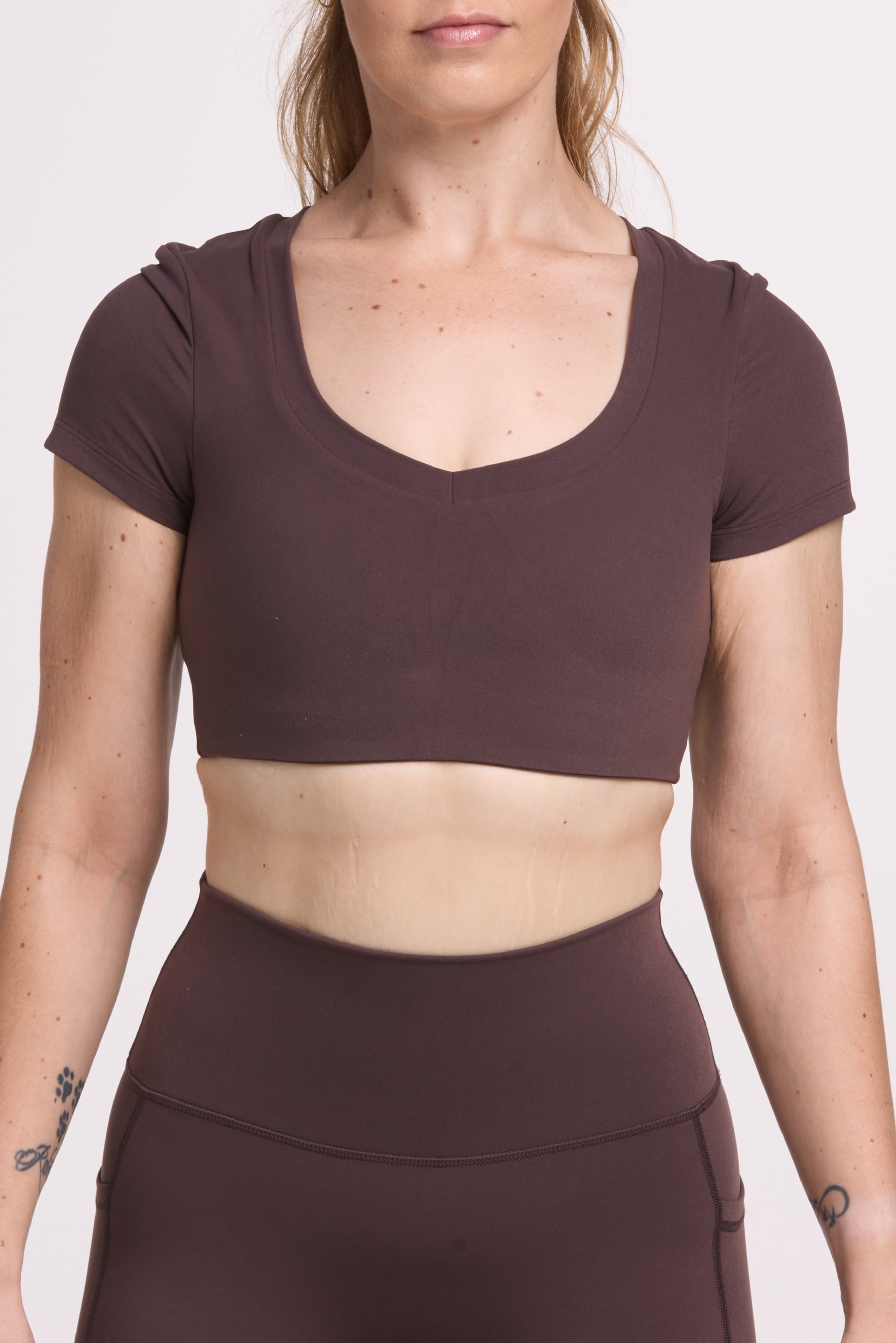 Buttery soft high waisted women's gym tights with practical pockets, sweetheart back seams for an upper glute shaping effect, and no front rise seam, paired with an V neck women's crop t-shirt with a supportive elasticated hem and triple layered fabric with removable pads for extra support in
chocolate