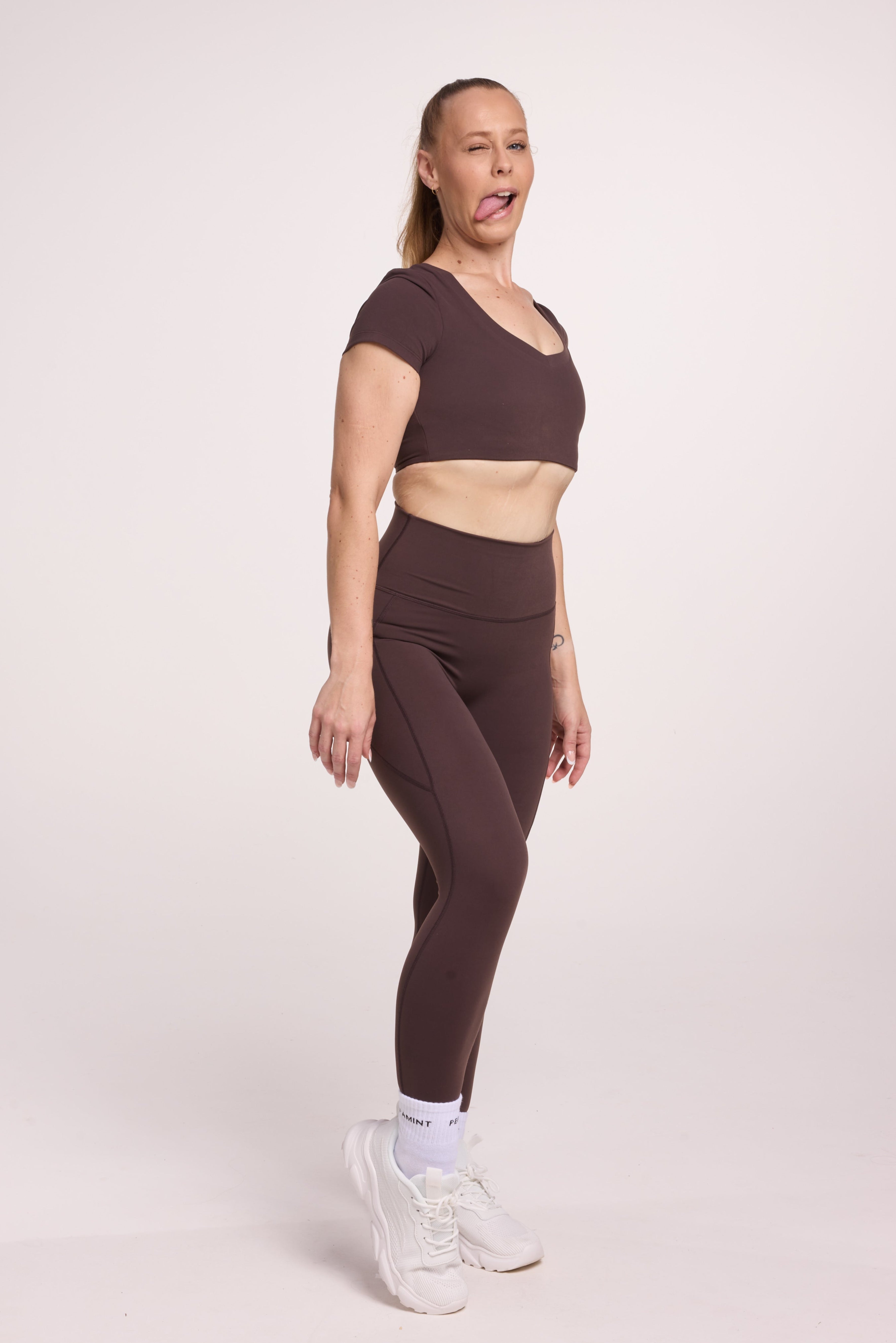 Buttery soft high waisted women's gym tights with practical pockets, sweetheart back seams for an upper glute shaping effect, and no front rise seam, paired with an V neck women's crop t-shirt with a supportive elasticated hem and triple layered fabric with removable pads for extra support in
chocolate