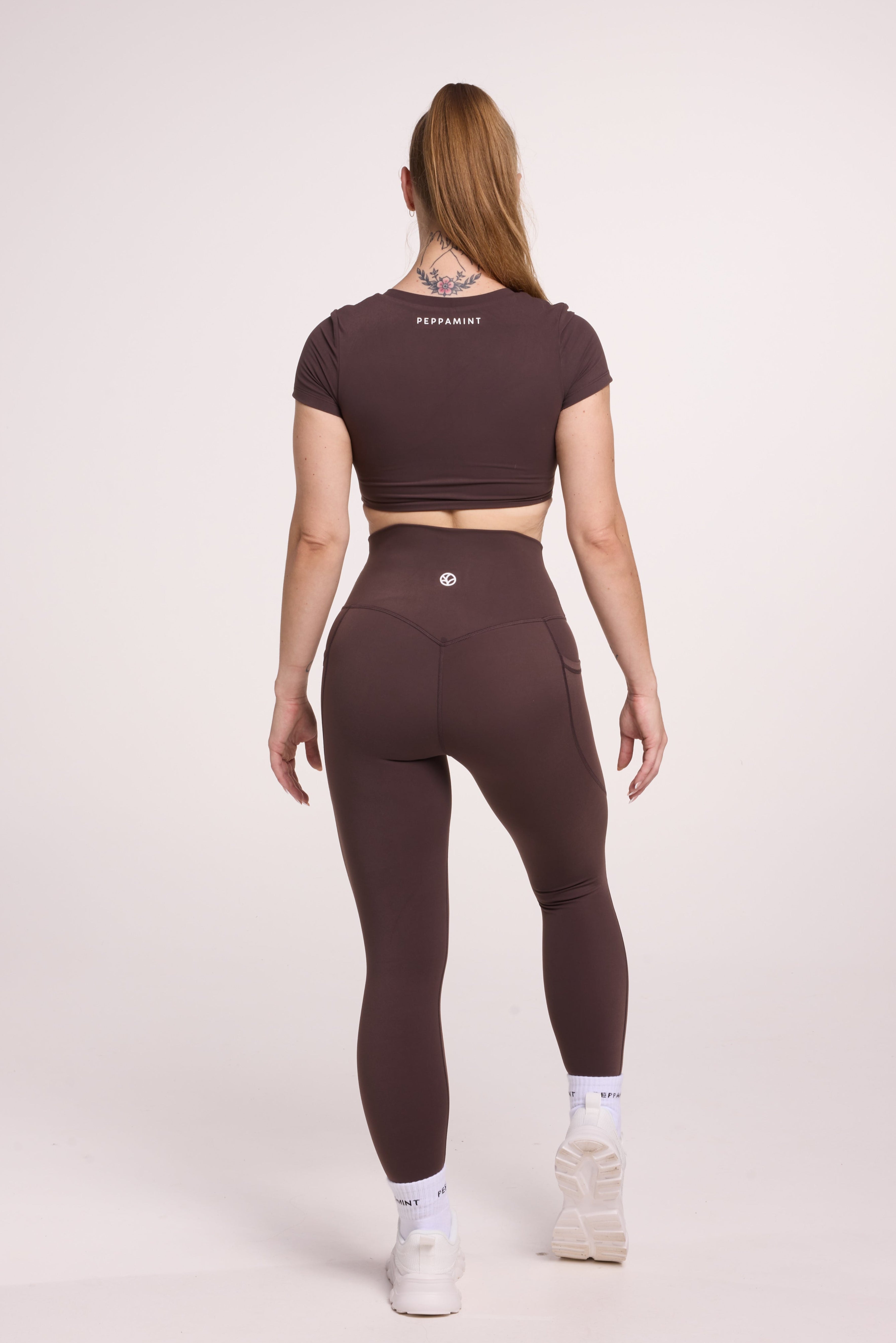 Buttery soft high waisted women's gym tights with practical pockets, sweetheart back seams for an upper glute shaping effect, and no front rise seam, paired with an V neck women's crop t-shirt with a supportive elasticated hem and triple layered fabric with removable pads for extra support in
chocolate