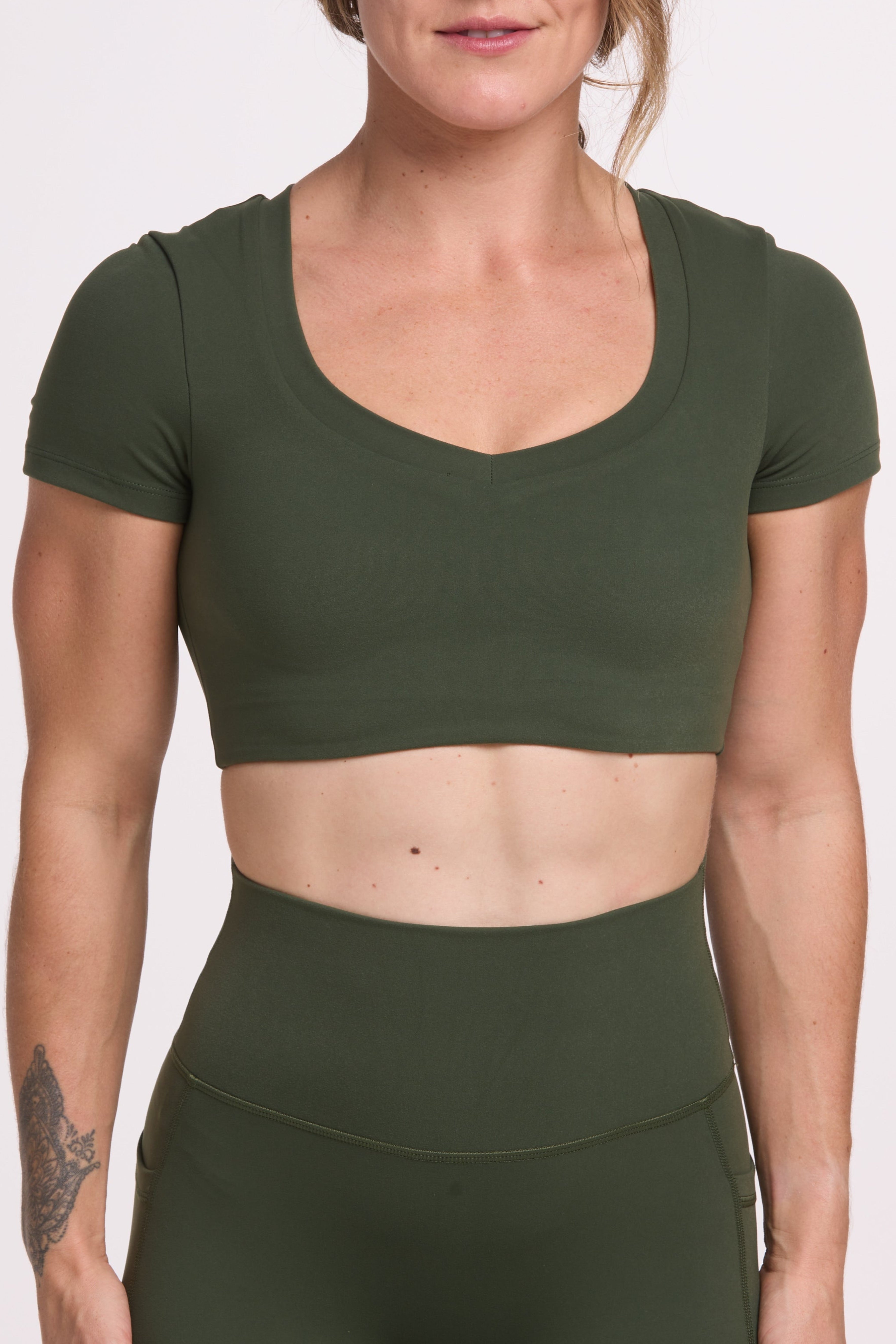 Buttery soft high waisted women's gym tights with practical pockets, sweetheart back seams for an upper glute shaping effect, and no front rise seam, paired with an V neck women's crop t-shirt with a supportive elasticated hem and triple layered fabric with removable pads for extra support in
forest green