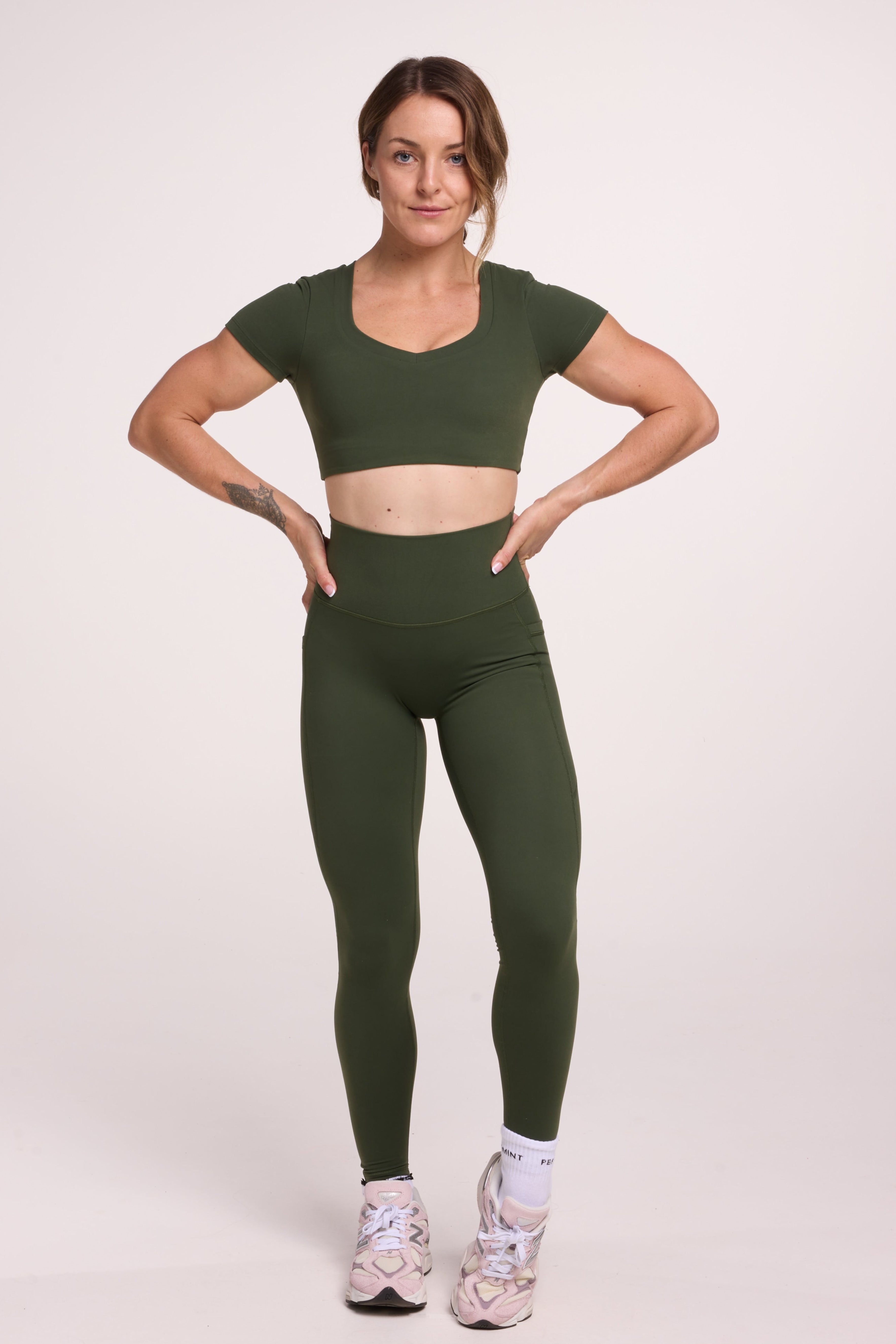 Buttery soft high waisted women's gym tights with practical pockets, sweetheart back seams for an upper glute shaping effect, and no front rise seam, paired with an V neck women's crop t-shirt with a supportive elasticated hem and triple layered fabric with removable pads for extra support in
forest green