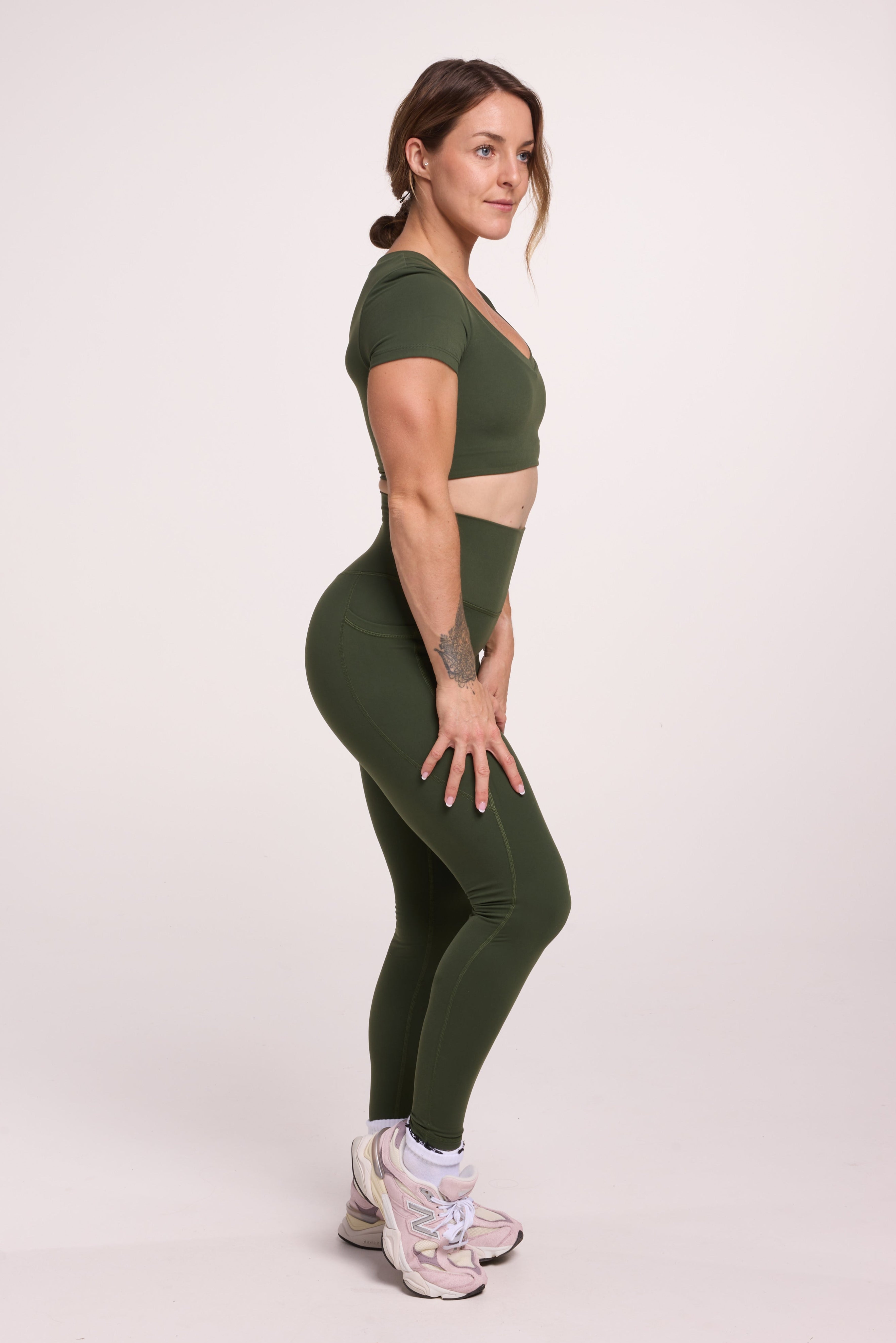 Buttery soft high waisted women's gym tights with practical pockets, sweetheart back seams for an upper glute shaping effect, and no front rise seam, paired with an V neck women's crop t-shirt with a supportive elasticated hem and triple layered fabric with removable pads for extra support in
forest green