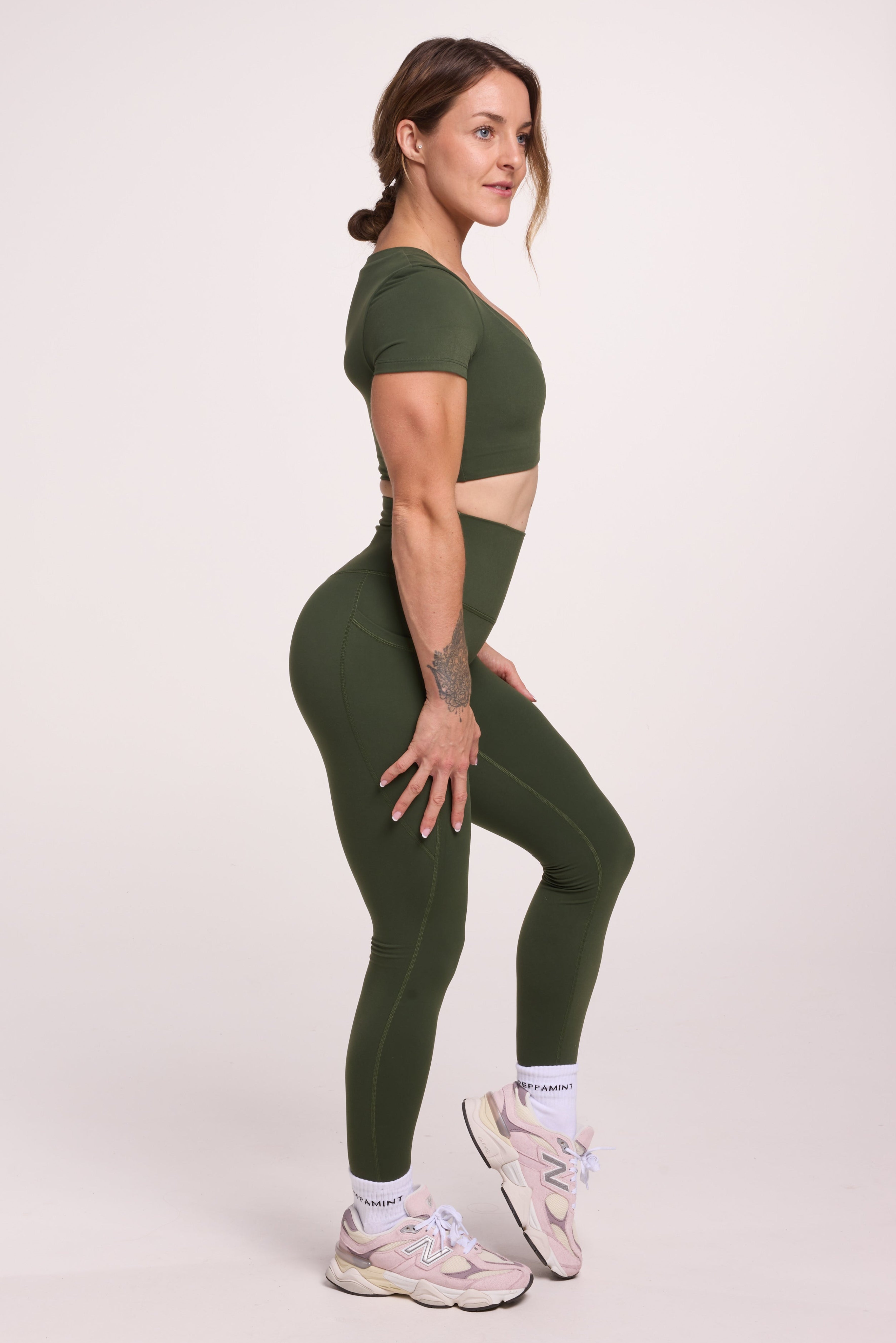 Buttery soft high waisted women's gym tights with practical pockets, sweetheart back seams for an upper glute shaping effect, and no front rise seam, paired with an V neck women's crop t-shirt with a supportive elasticated hem and triple layered fabric with removable pads for extra support in
forest green