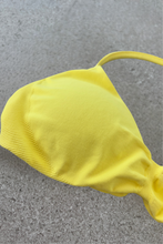 Load image into Gallery viewer, Minimalistic bra with breast contouring panels and a ruched front seam to effortlessy shape the breasts, with a sleek back straps and halter neck design for showcasing the back gains in buttercup yellow