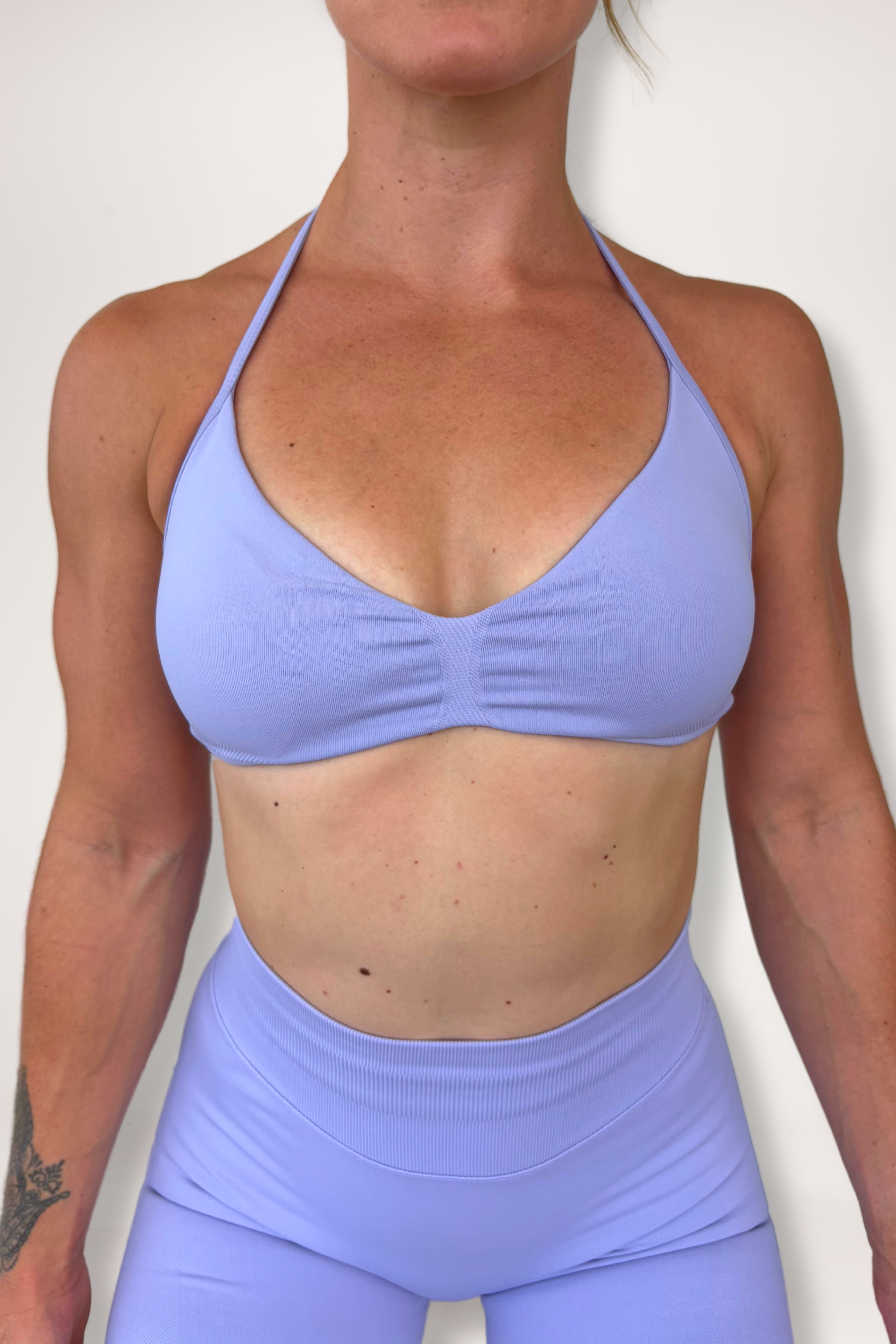 Minimalistic bra with breast contouring panels and a ruched front seam to effortlessy shape the breasts, with a sleek back straps and halter neck design for showcasing the back gains in lavender
