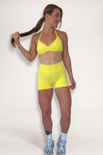 Load image into Gallery viewer, Seamless shorts with booty contouring panels, glute shaping seams, a thick supportive waistband paired with a minimalistic bra with sleek back straps and halter neck design for showcasing the back gains in buttercup yellow