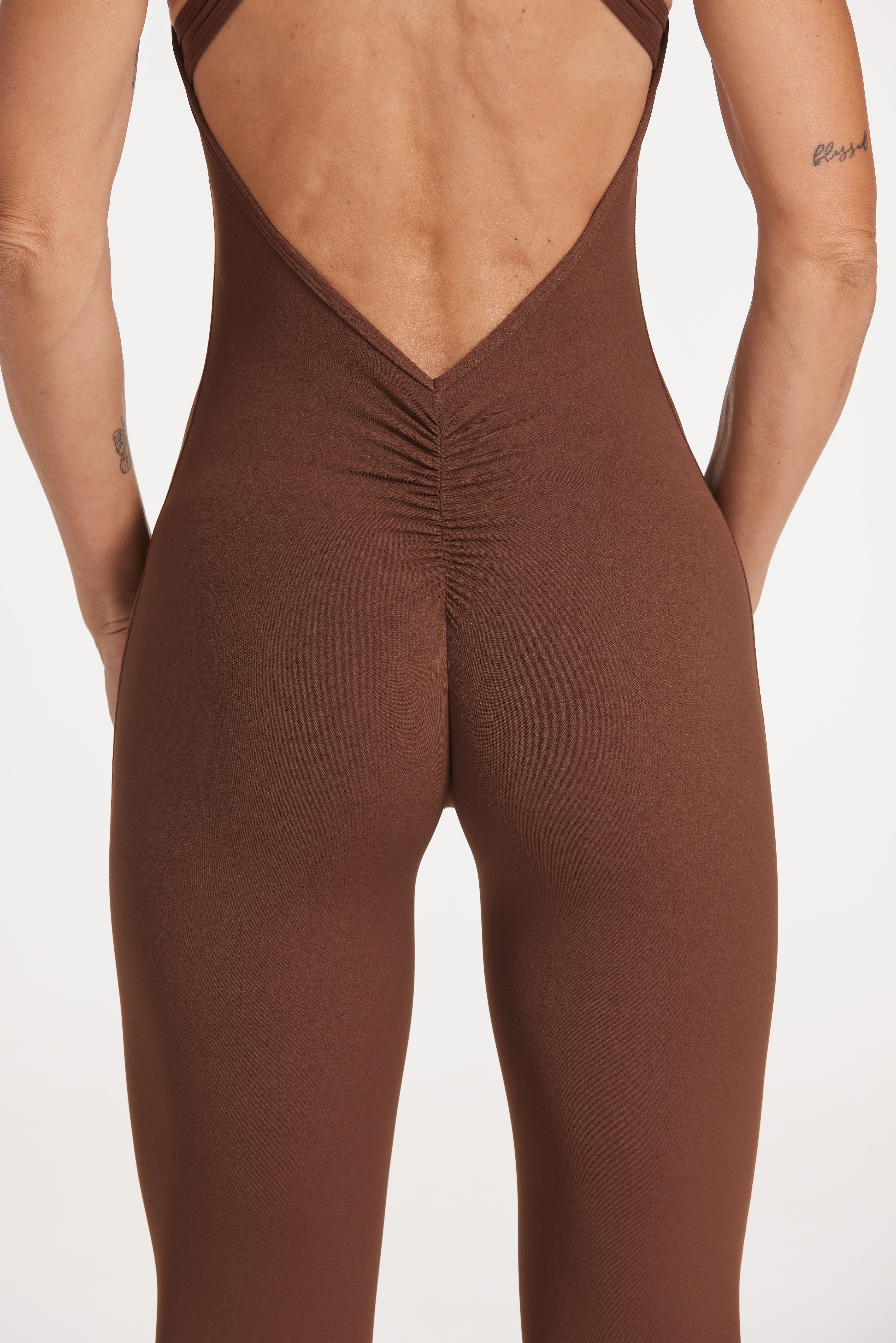 full leg length bodysuit in buttery soft fabric with half zipper, high neck design, scrunch butt, and open back detail.