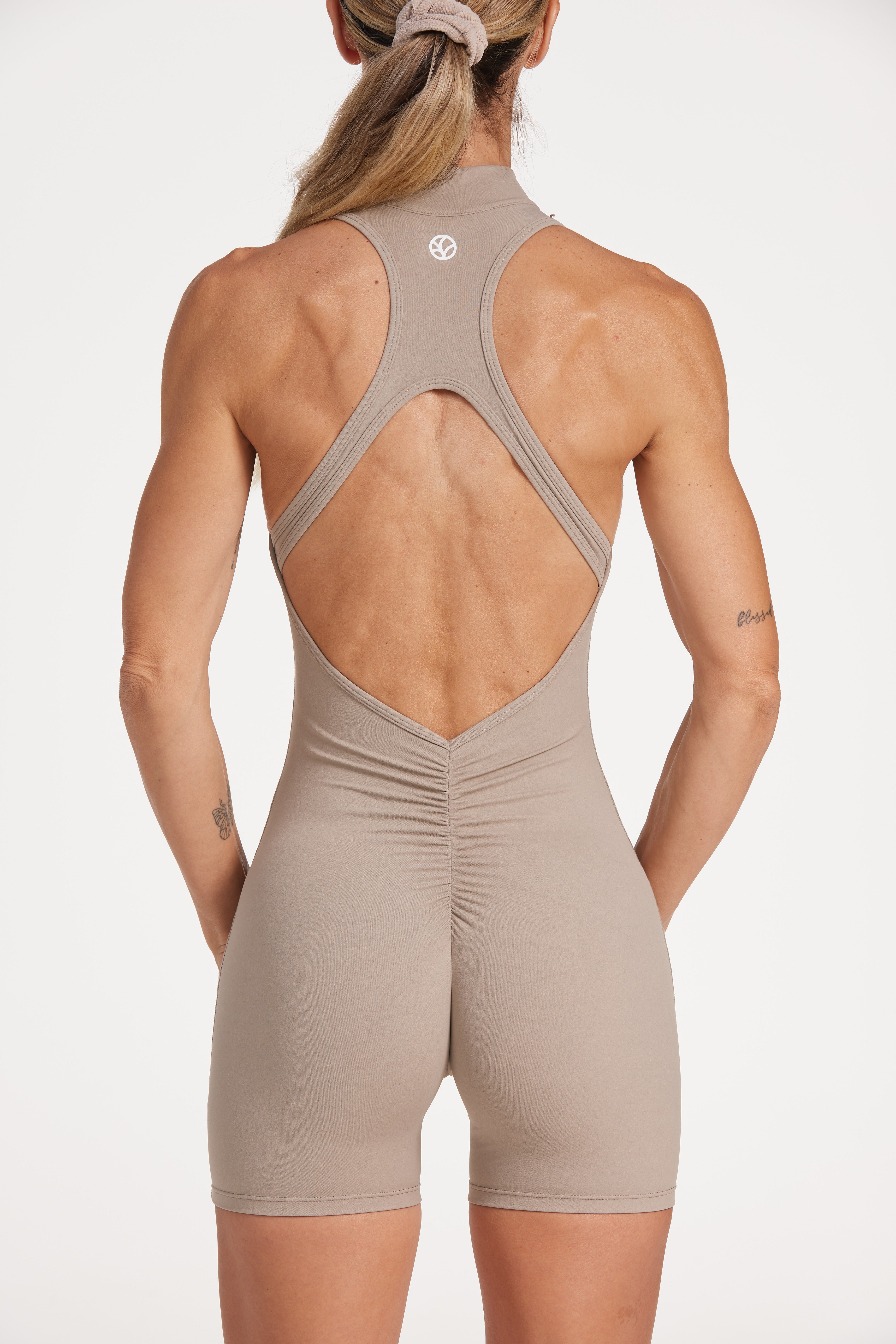 High neck bodysuit with half zipper, scrunch bum detailing, in short length made from a buttery soft flexible fabric in pumice stone