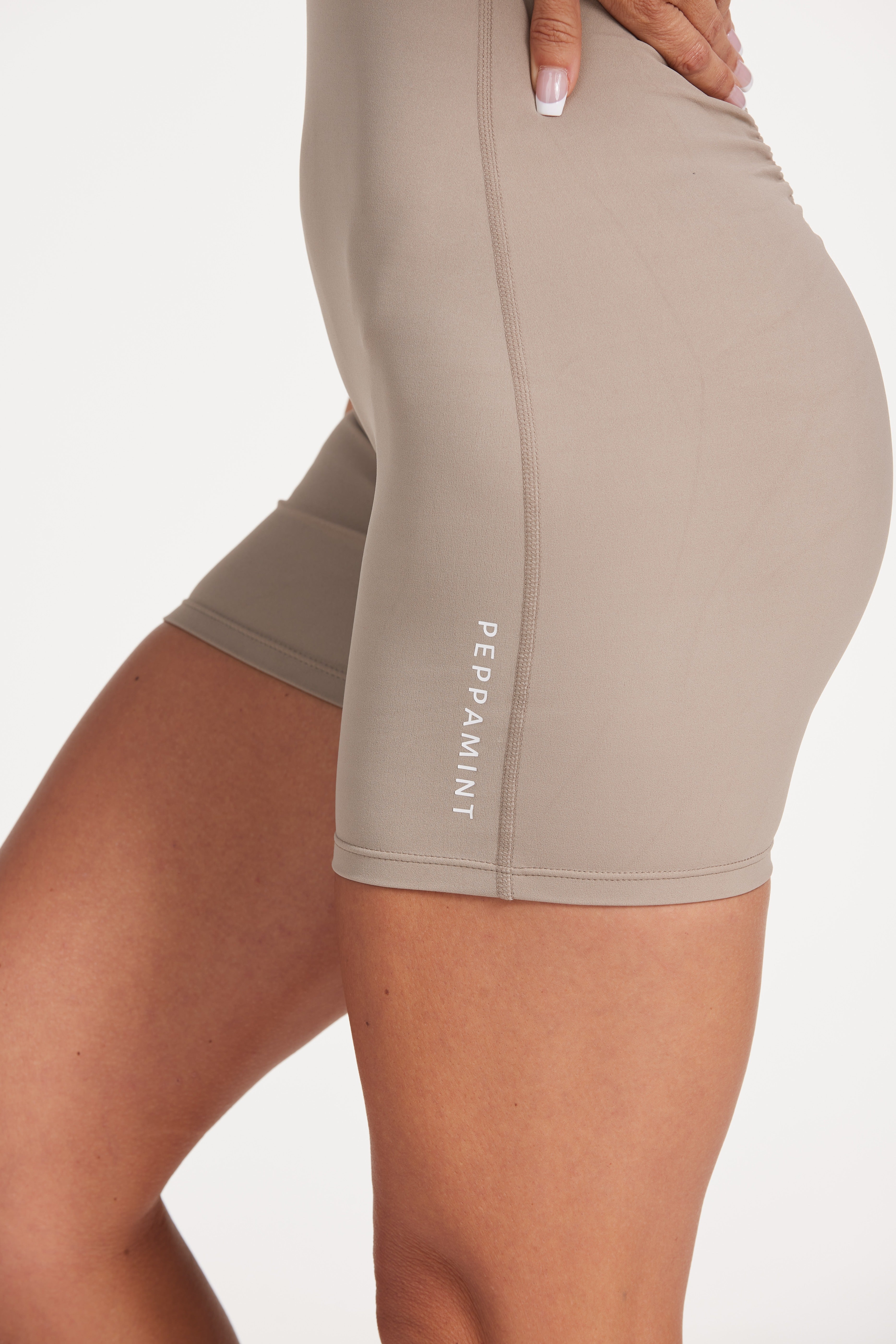 High neck bodysuit with half zipper, scrunch bum detailing, in short length made from a buttery soft flexible fabric in pumice stone