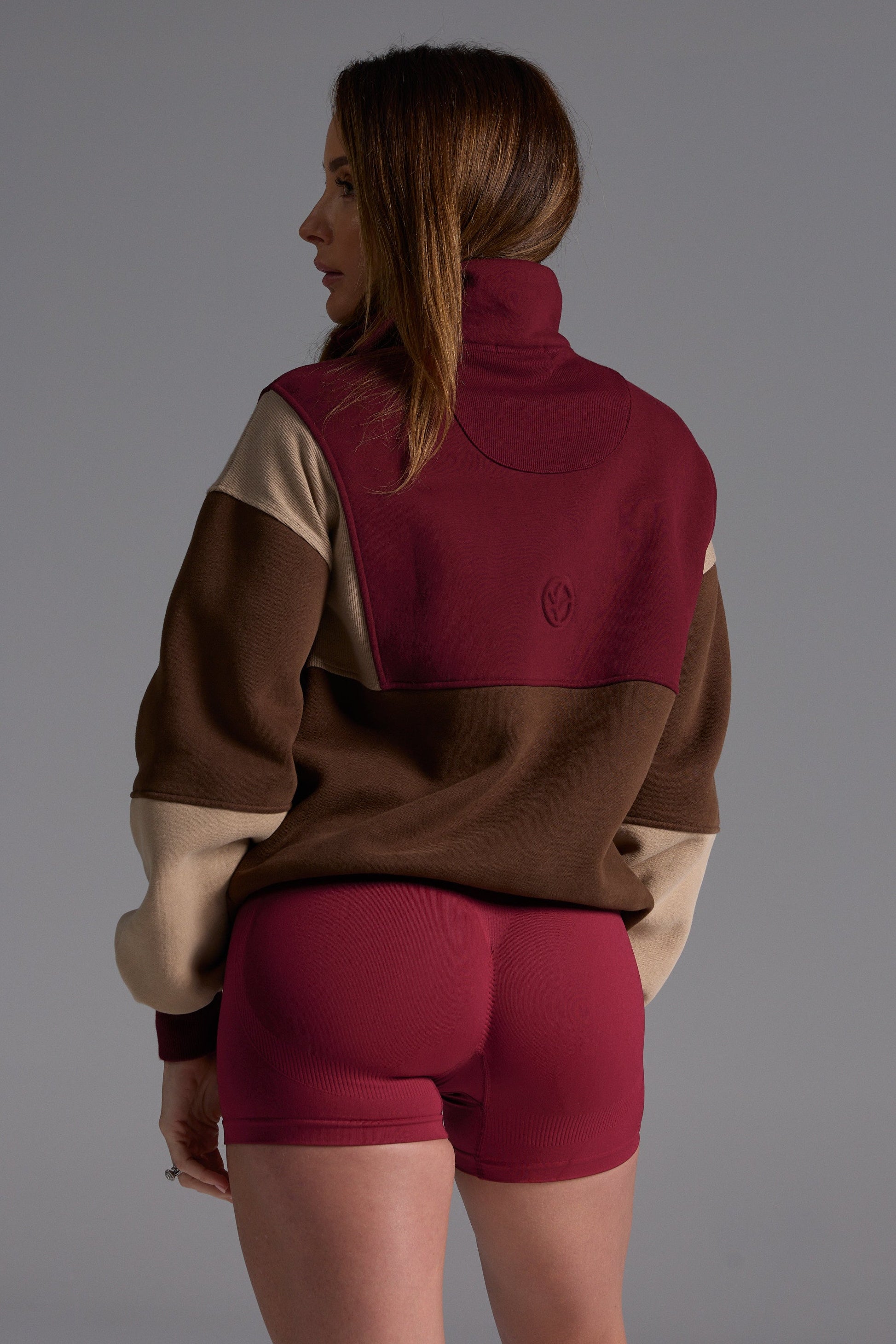 1/4 zip fleece jumper with double collar, ribbed stretchy fabric panel inserts, and two convenient zip pockets in a wine, chocolate and beige colour block design.