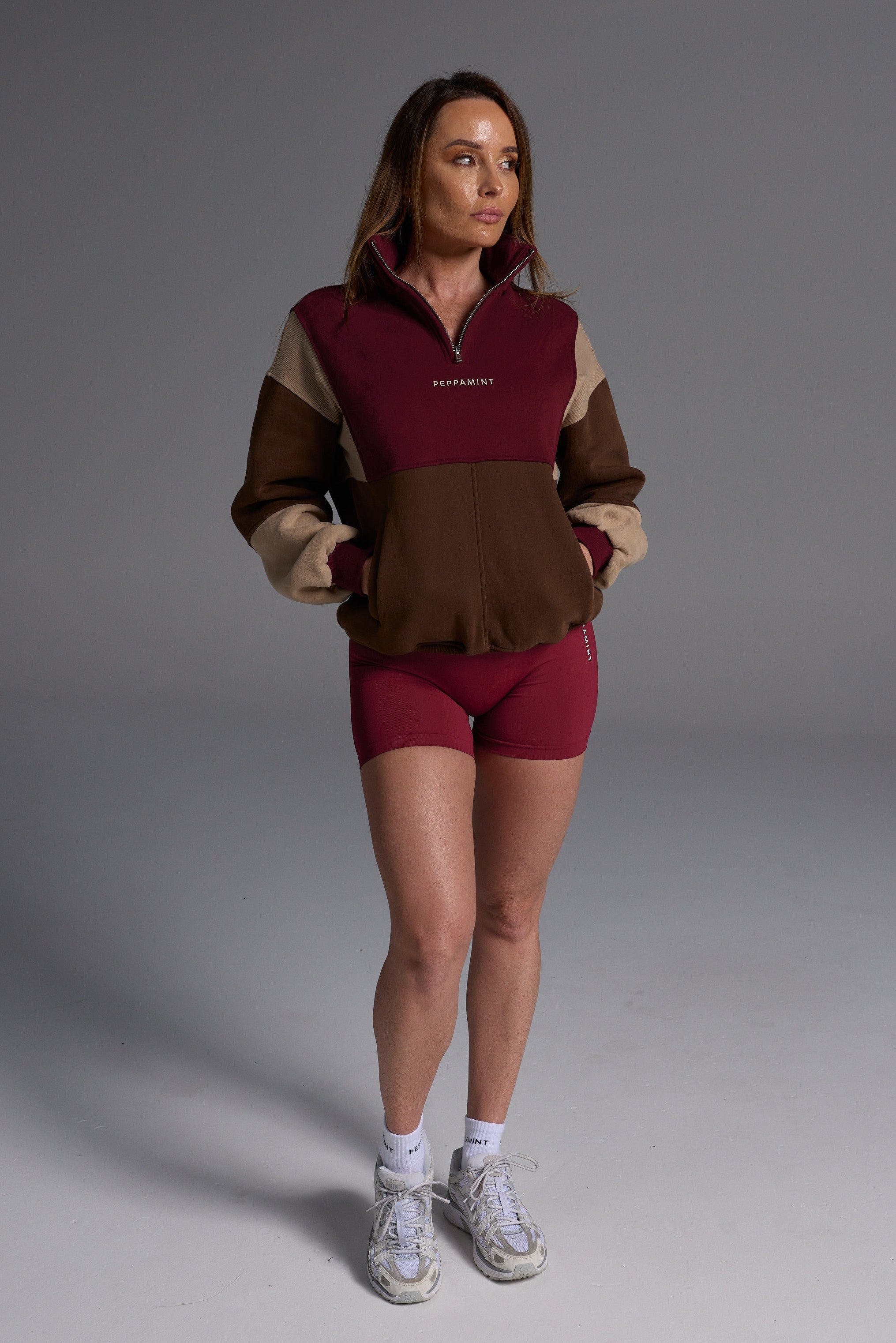 1/4 zip fleece jumper with double collar, ribbed stretchy fabric panel inserts, and two convenient zip pockets in a wine, chocolate and beige colour block design.