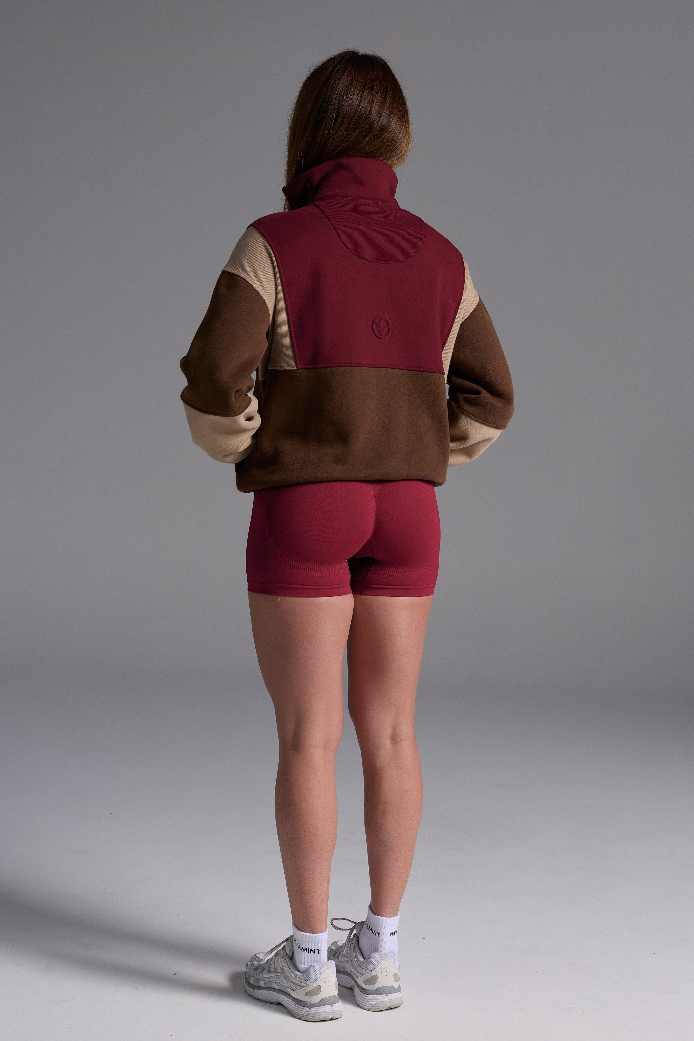 1/4 zip fleece jumper with double collar, ribbed stretchy fabric panel inserts, and two convenient zip pockets in a wine, chocolate and beige colour block design.