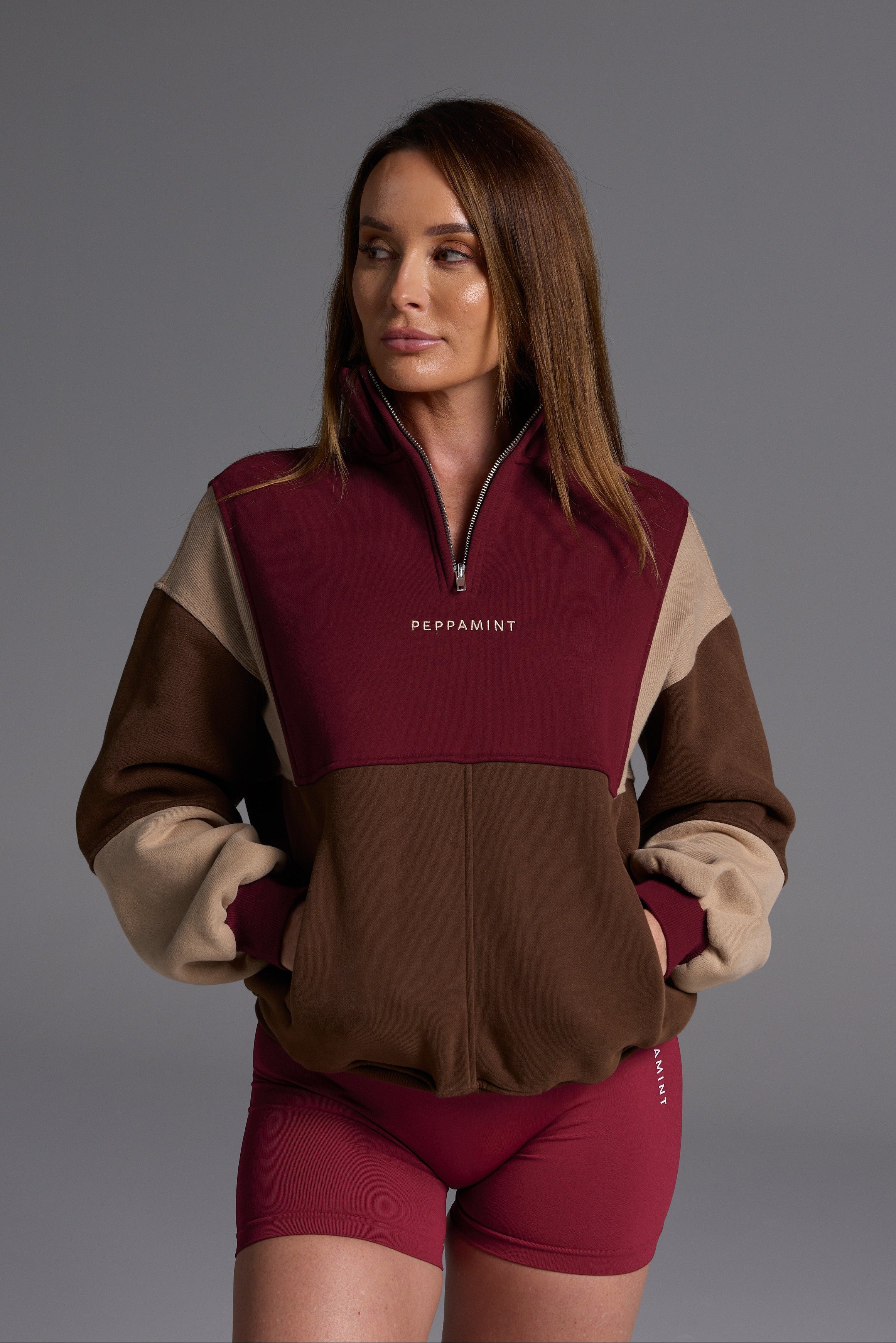 1/4 zip fleece jumper with double collar, ribbed stretchy fabric panel inserts, and two convenient zip pockets in a wine, chocolate and beige colour block design.