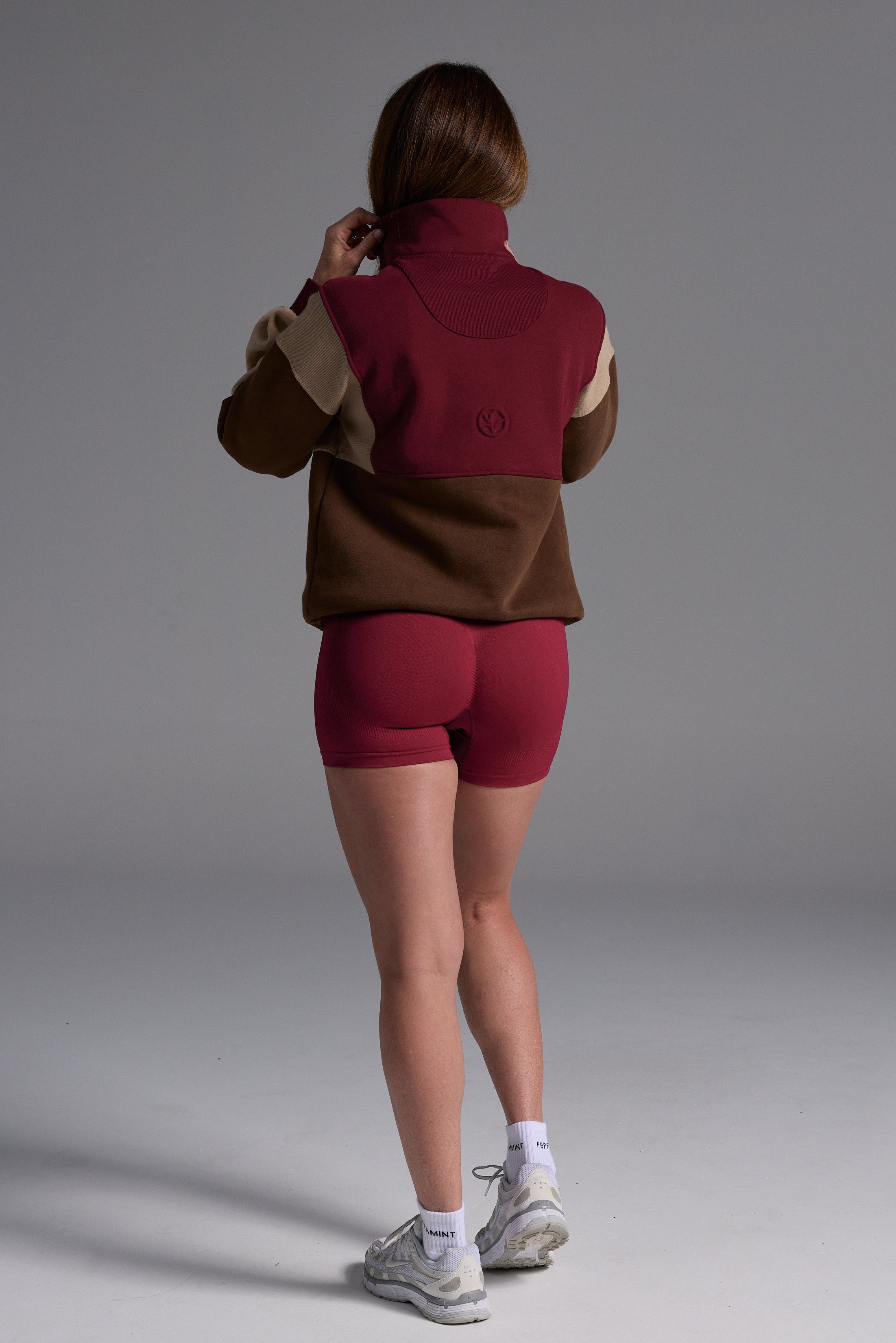 1/4 zip fleece jumper with double collar, ribbed stretchy fabric panel inserts, and two convenient zip pockets in a wine, chocolate and beige colour block design.