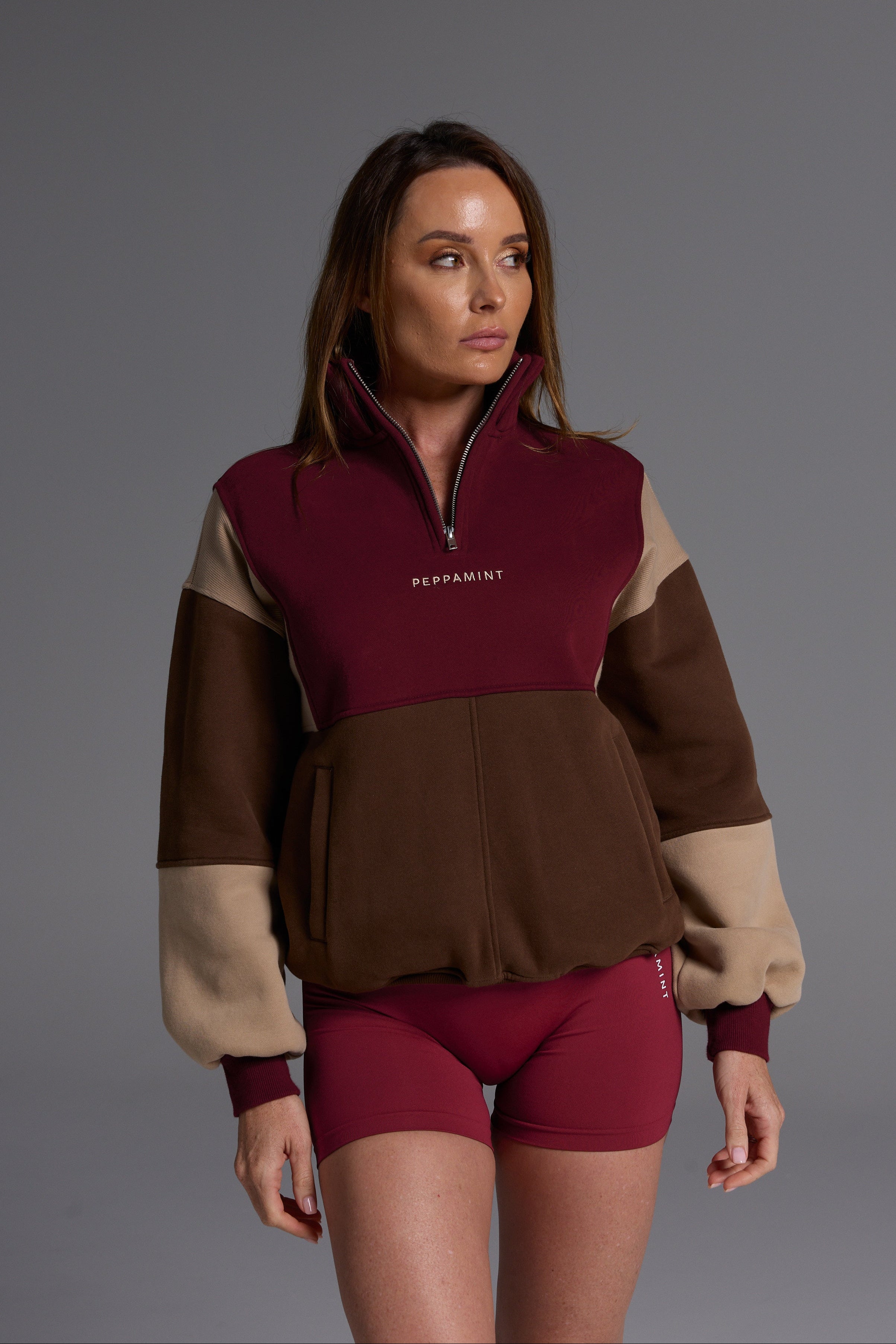 1/4 zip fleece jumper with double collar, ribbed stretchy fabric panel inserts, and two convenient zip pockets in a wine, chocolate and beige colour block design.