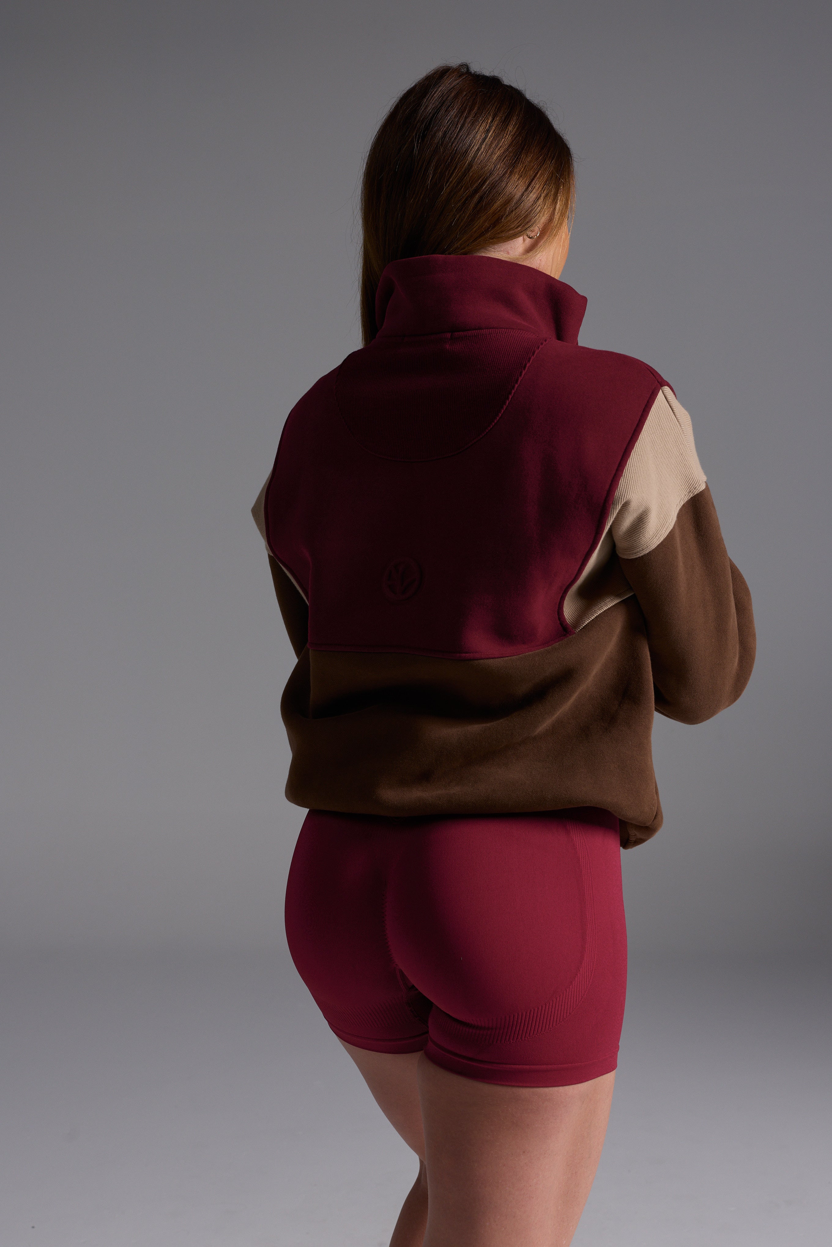 1/4 zip fleece jumper with double collar, ribbed stretchy fabric panel inserts, and two convenient zip pockets in a wine, chocolate and beige colour block design.
