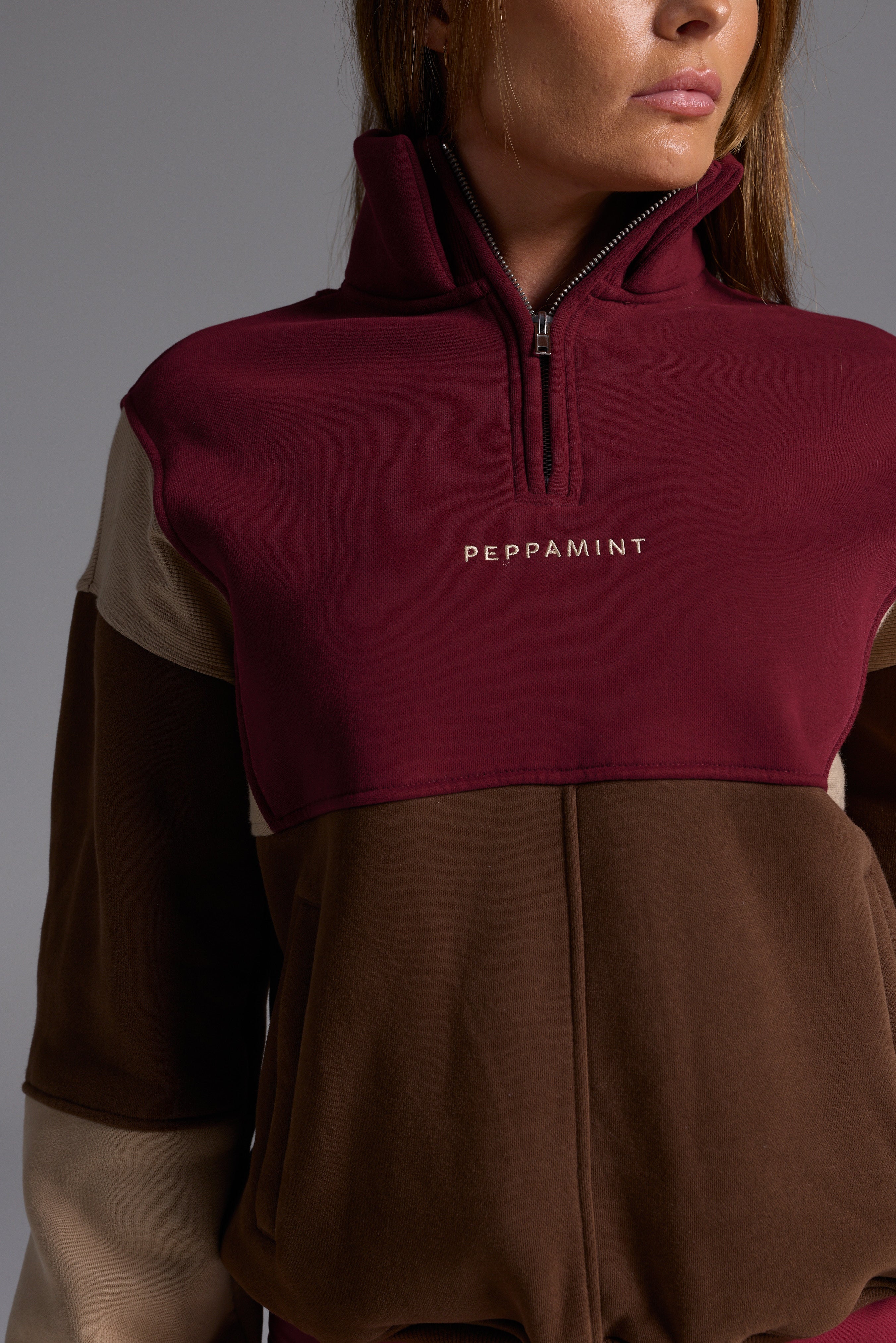 1/4 zip fleece jumper with double collar, ribbed stretchy fabric panel inserts, and two convenient zip pockets in a wine, chocolate and beige colour block design.