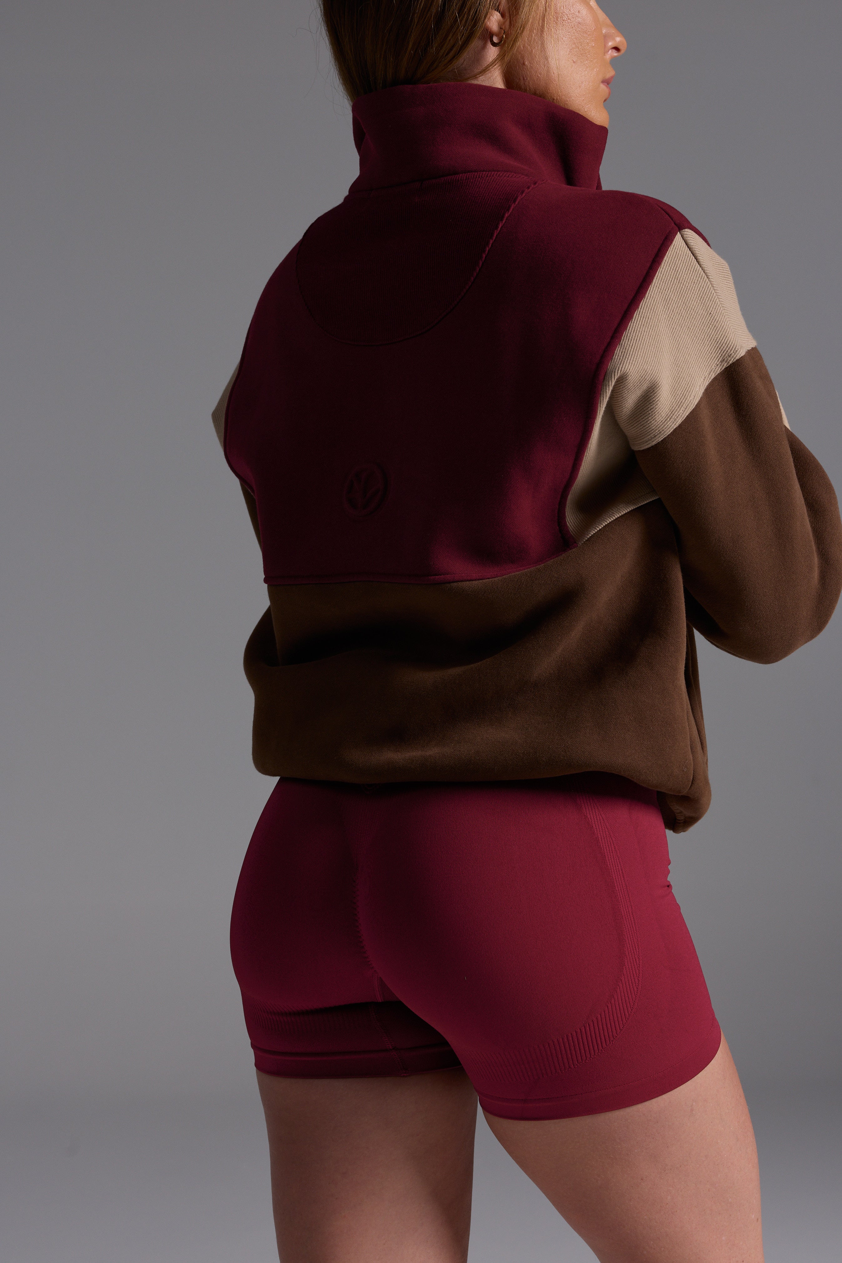 1/4 zip fleece jumper with double collar, ribbed stretchy fabric panel inserts, and two convenient zip pockets in a wine, chocolate and beige colour block design.