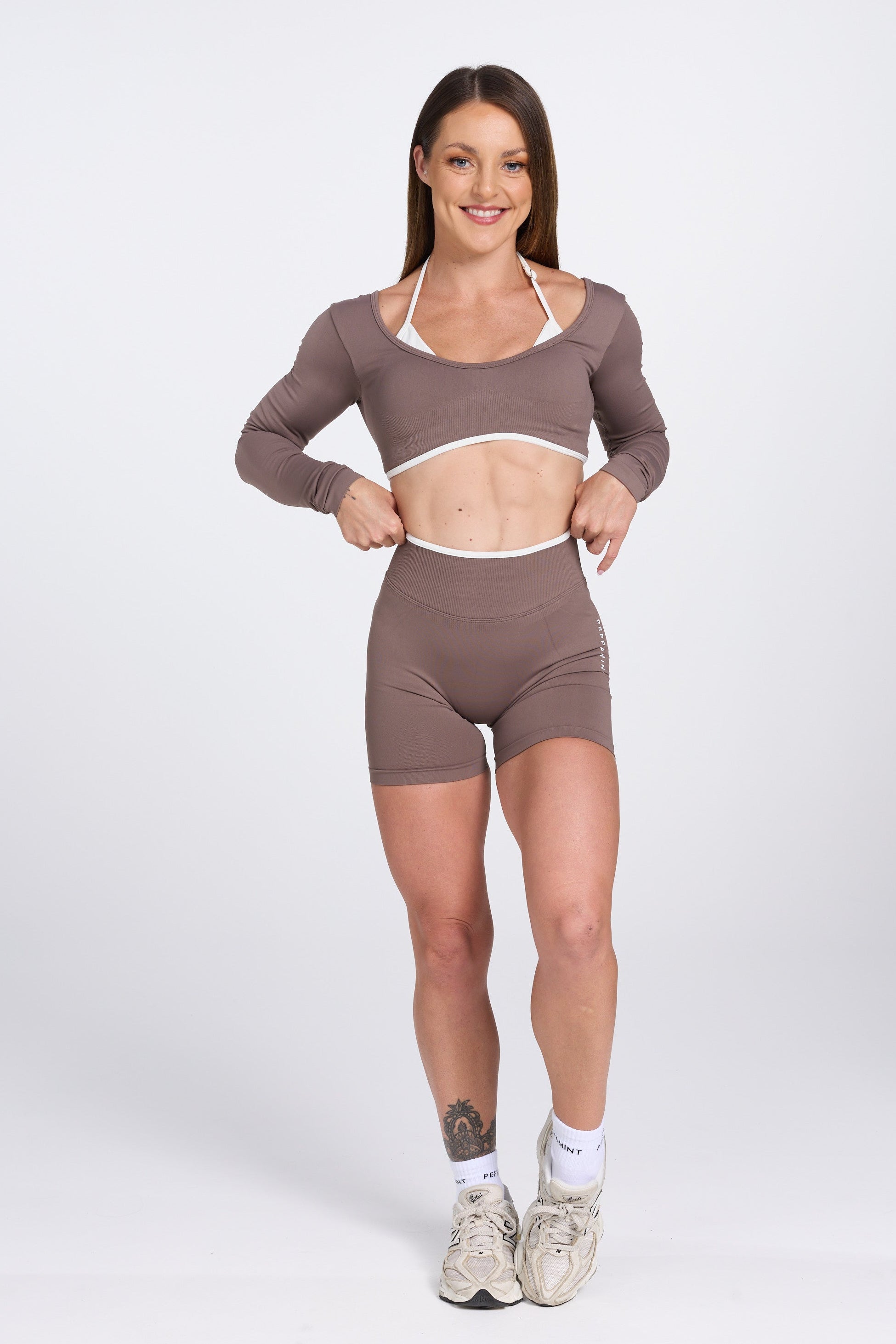 Long sleeve seamless crop top, with built in white contrasting bra, luxe white trim, and adjustable halter strap, with high waisted booty sculpting gym shorts in Mocha.