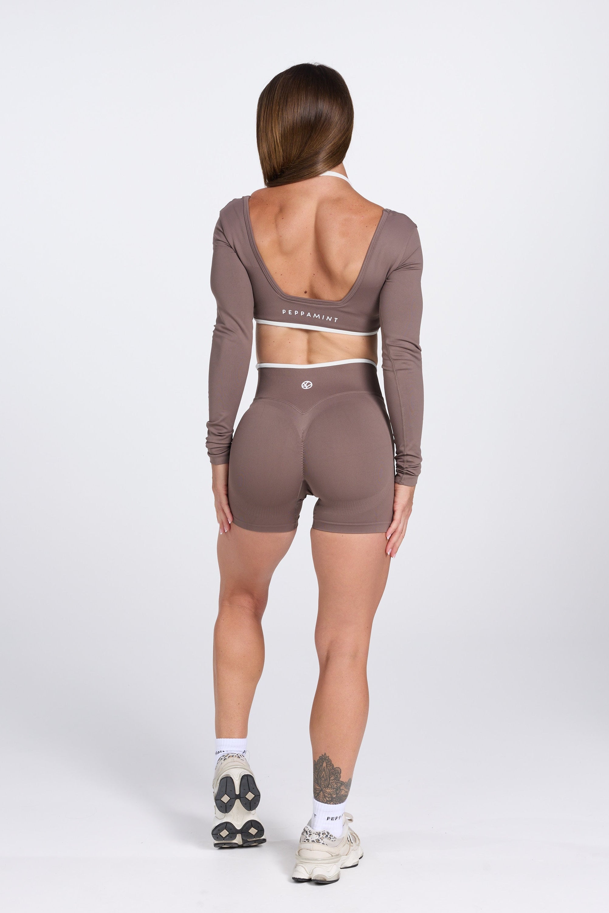 Long sleeve seamless crop top, with built in white contrasting bra, luxe white trim, and adjustable halter strap, with high waisted booty sculpting gym shorts in Mocha.