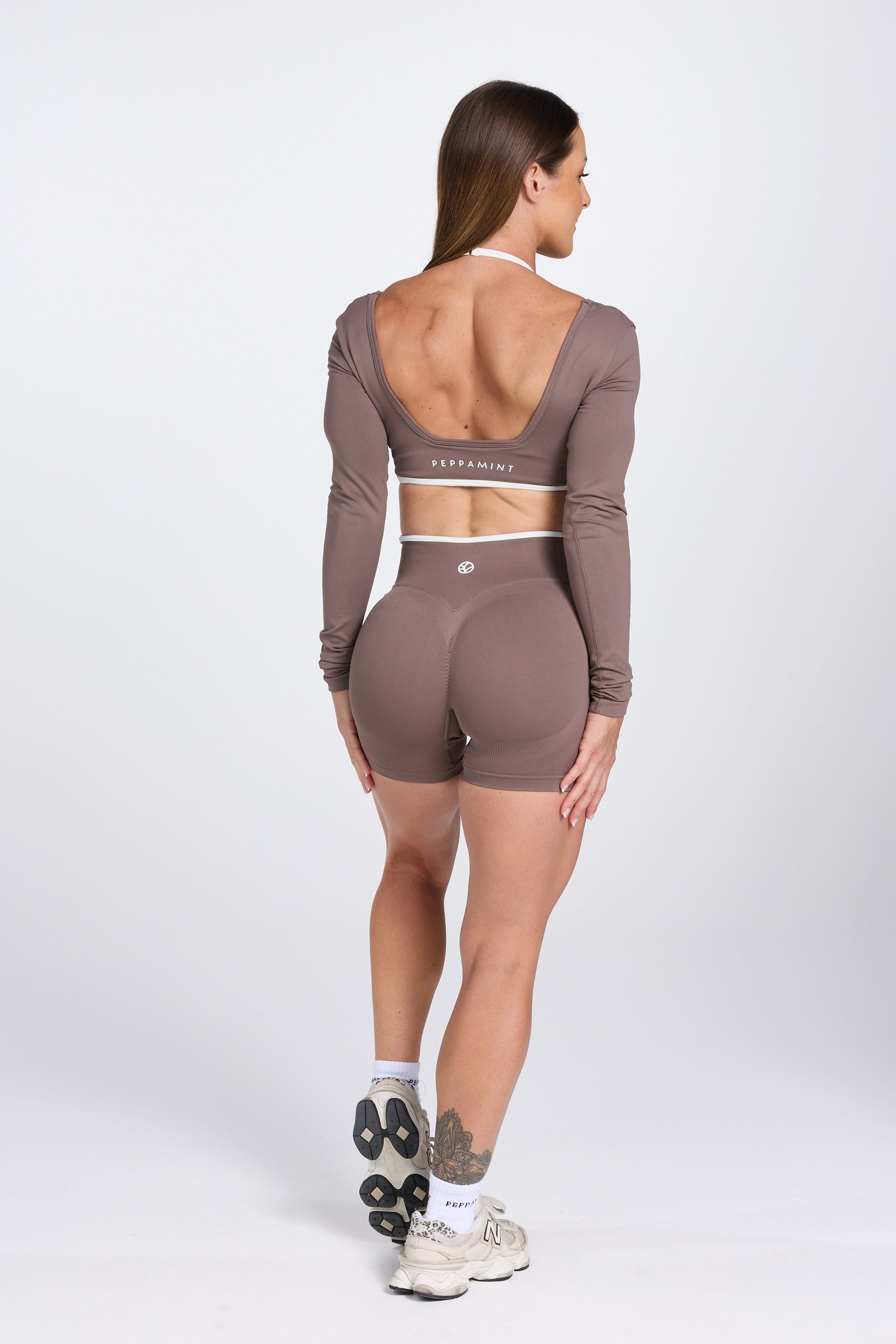 Long sleeve seamless crop top, with built in white contrasting bra, luxe white trim, and adjustable halter strap, with high waisted booty sculpting gym shorts in Mocha.