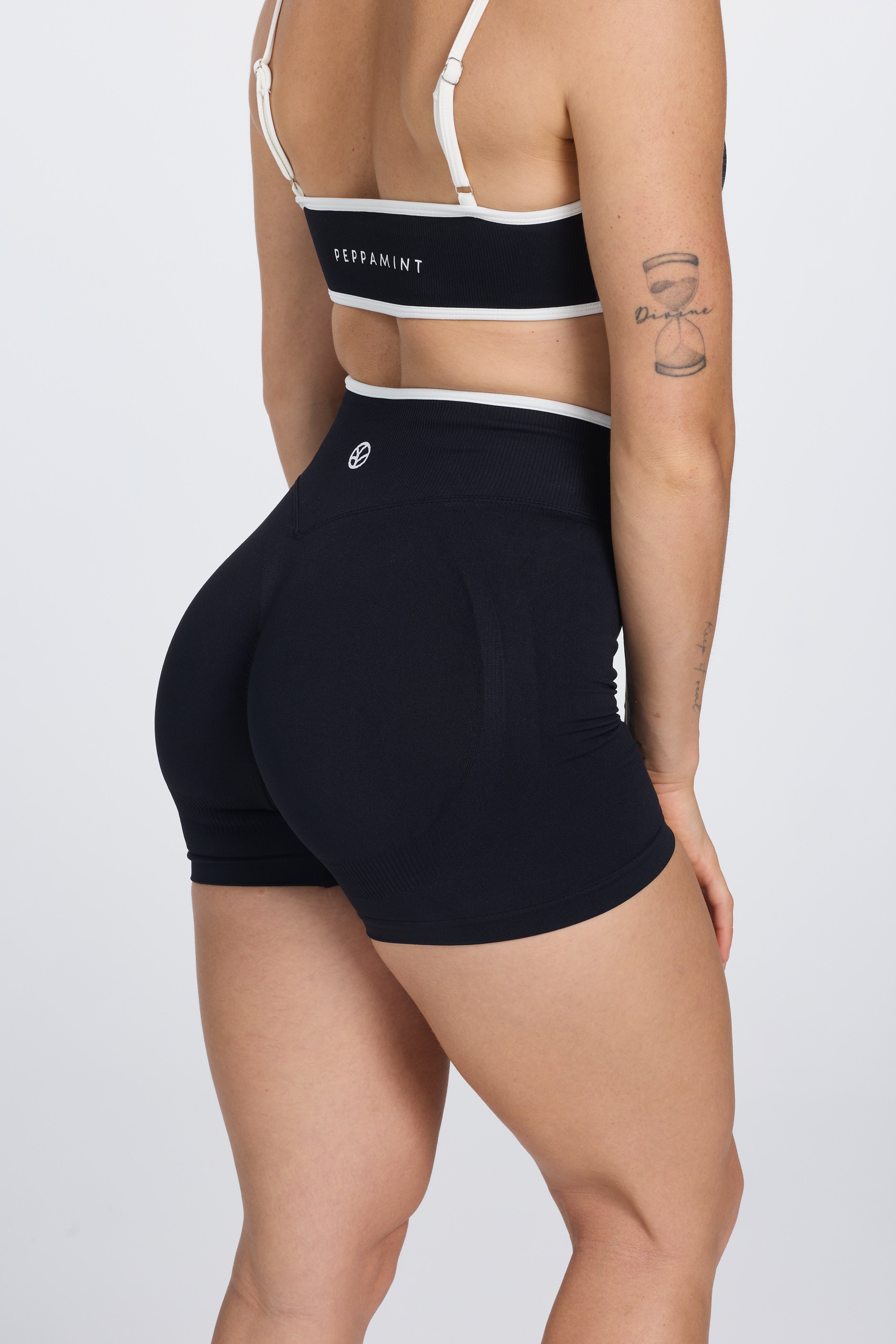 High waisted seamless gym shorts, with textured booty sculpting panels, and a luxe white trim, in black colour.