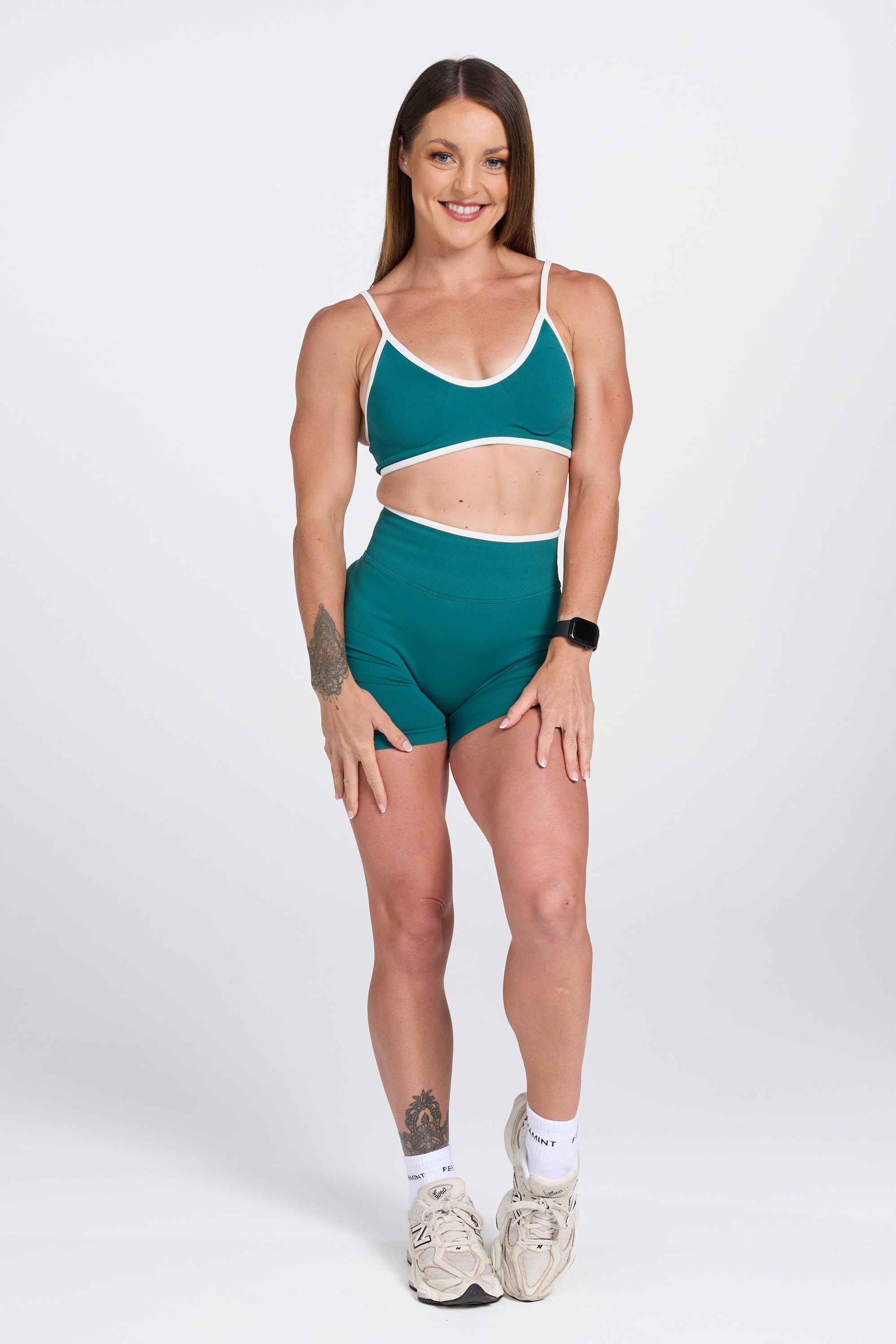 Seamless gym bra, with luxe white trim and adjustable back straps in teal colour.