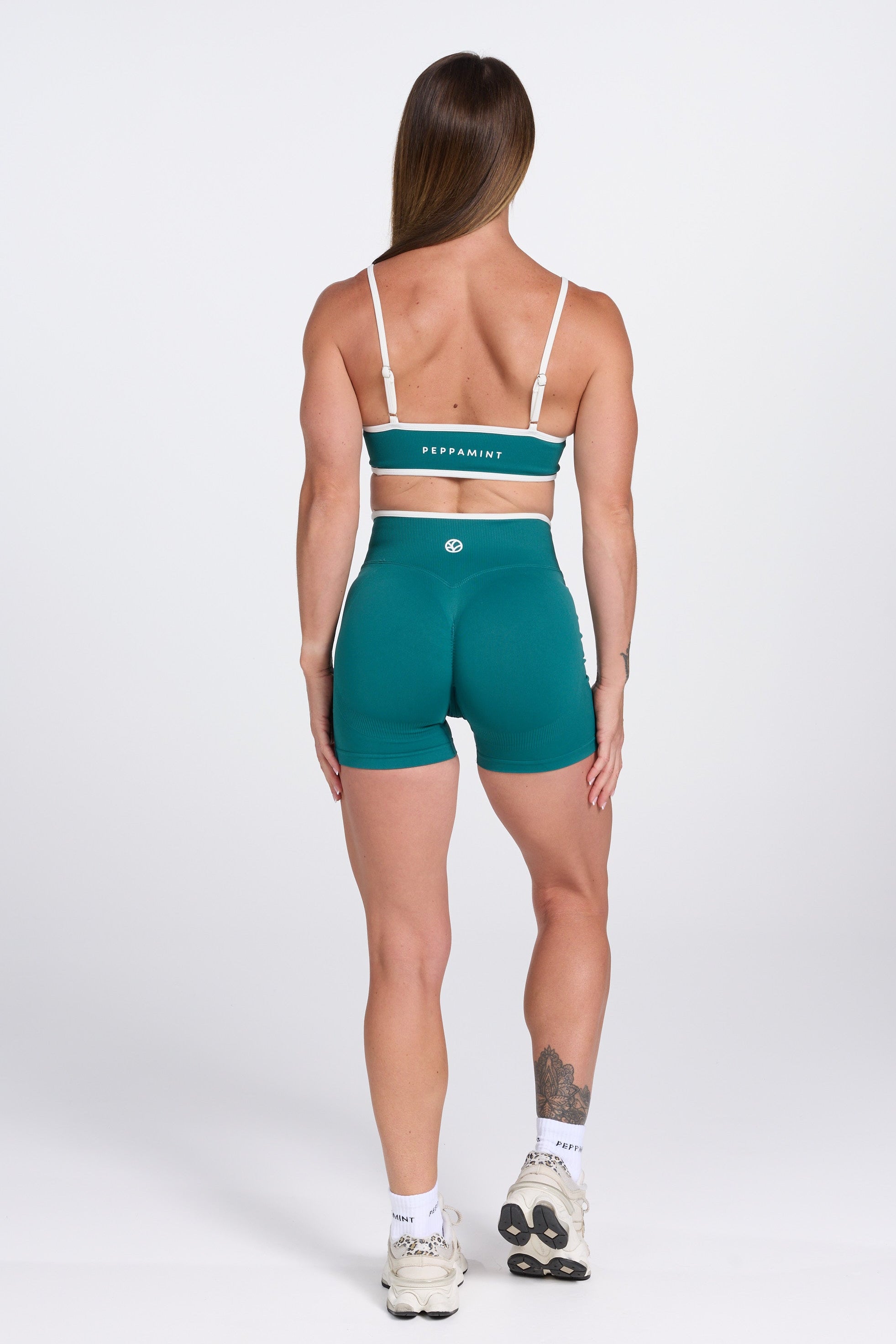 Seamless gym bra, with luxe white trim and adjustable back straps in teal colour.