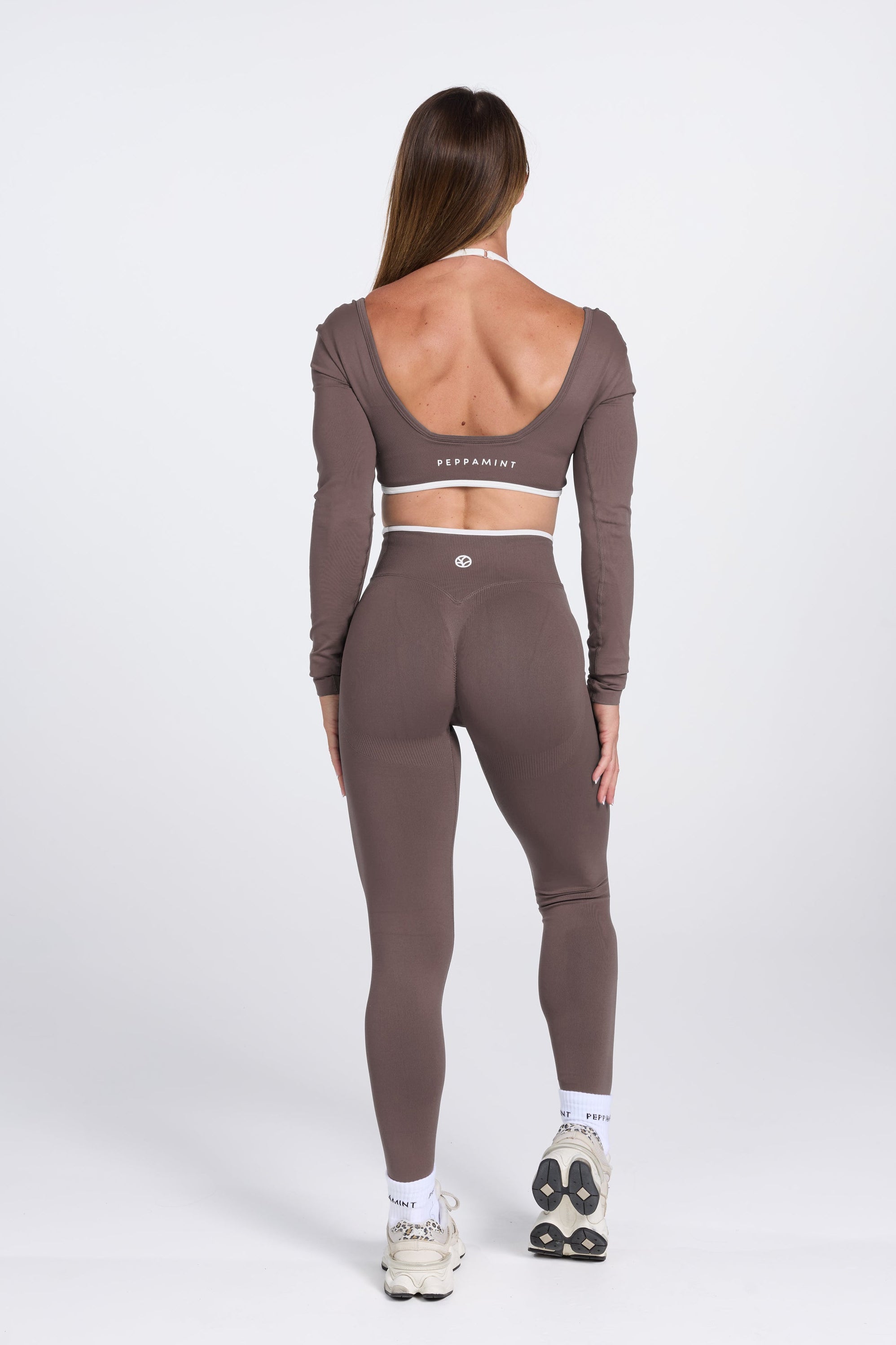 Long sleeve seamless crop top, with built in white contrasting bra, luxe white trim, and adjustable halter strap, with high waisted booty sculpting gym tights in Mocha.