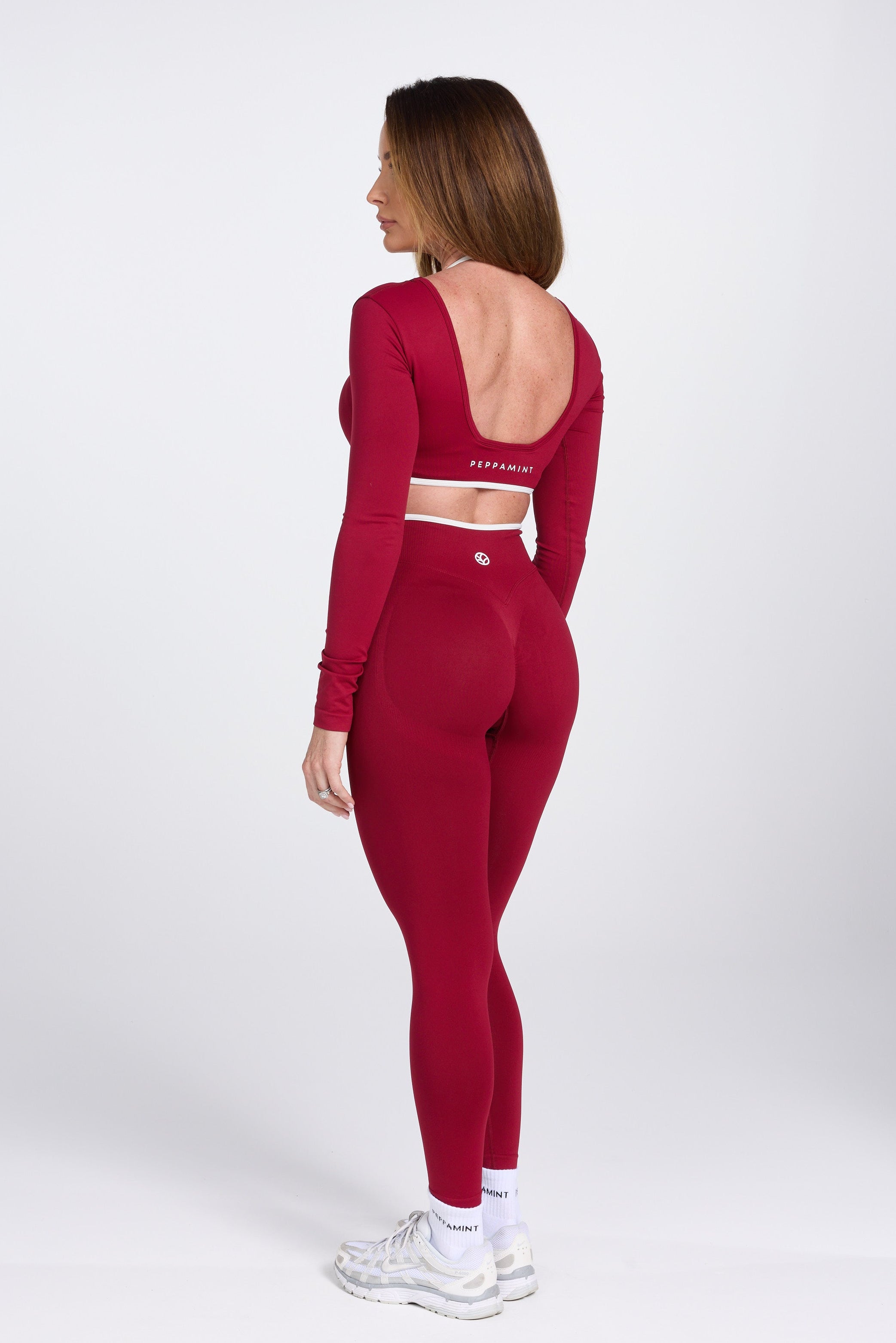 Long sleeve seamless crop top, with built in white contrasting bra, luxe white trim, and adjustable halter strap in wine colour.