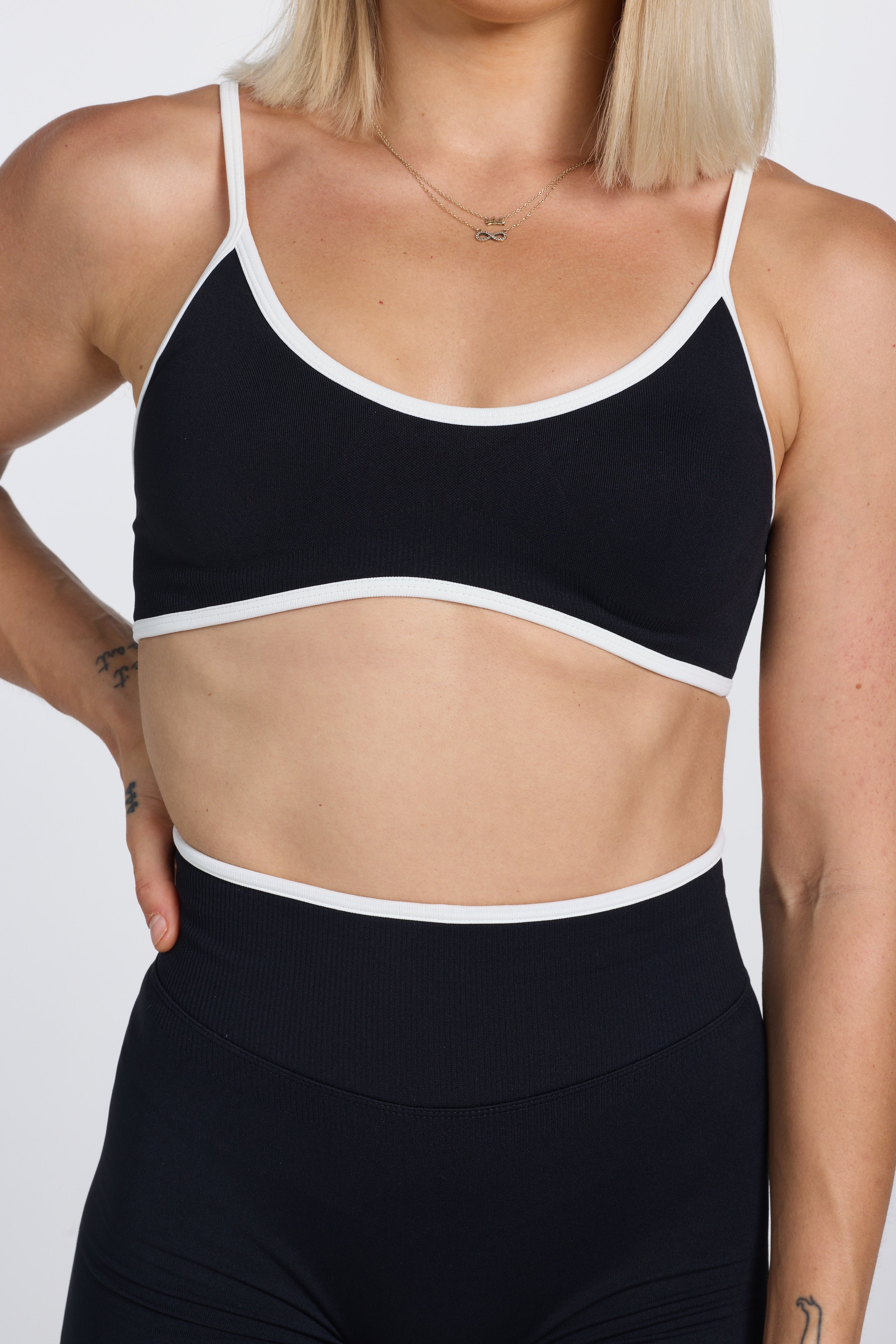 Seamless gym bra, with luxe white trim and adjustable back straps in black colour.