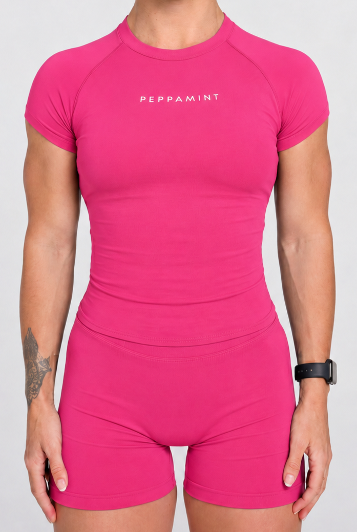 Person wearing a pink shirt and shorts with 'PEPPAMINT' branding on a white background