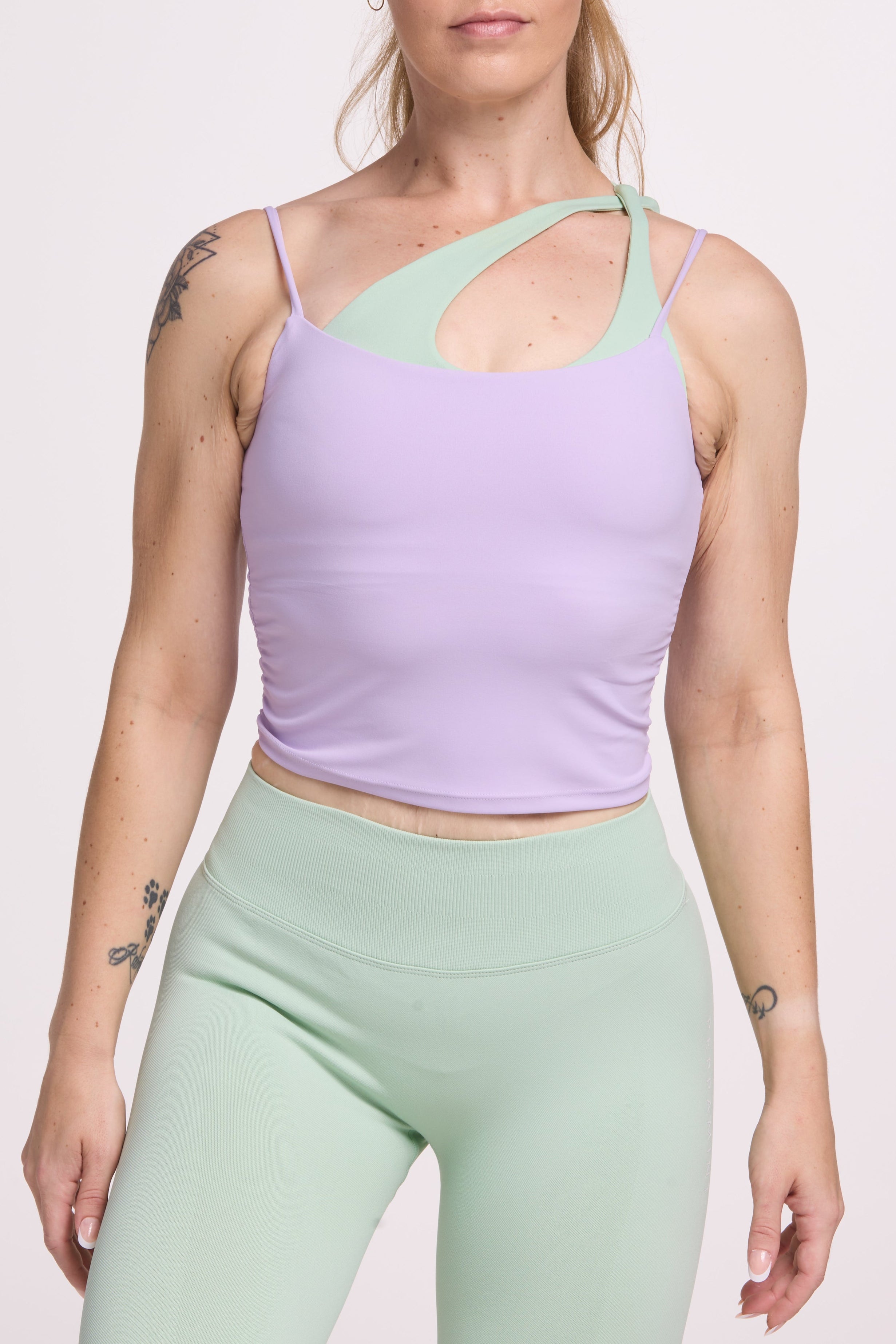 Buttery soft singlet with ruched side seams, spaghetti straps and built in shelf bra with removable pads in lavender with seamless gym tights with booty contouring panels, invisible scrunch technology, sweetheart shaped back seams and thick supportive fabric in mist green