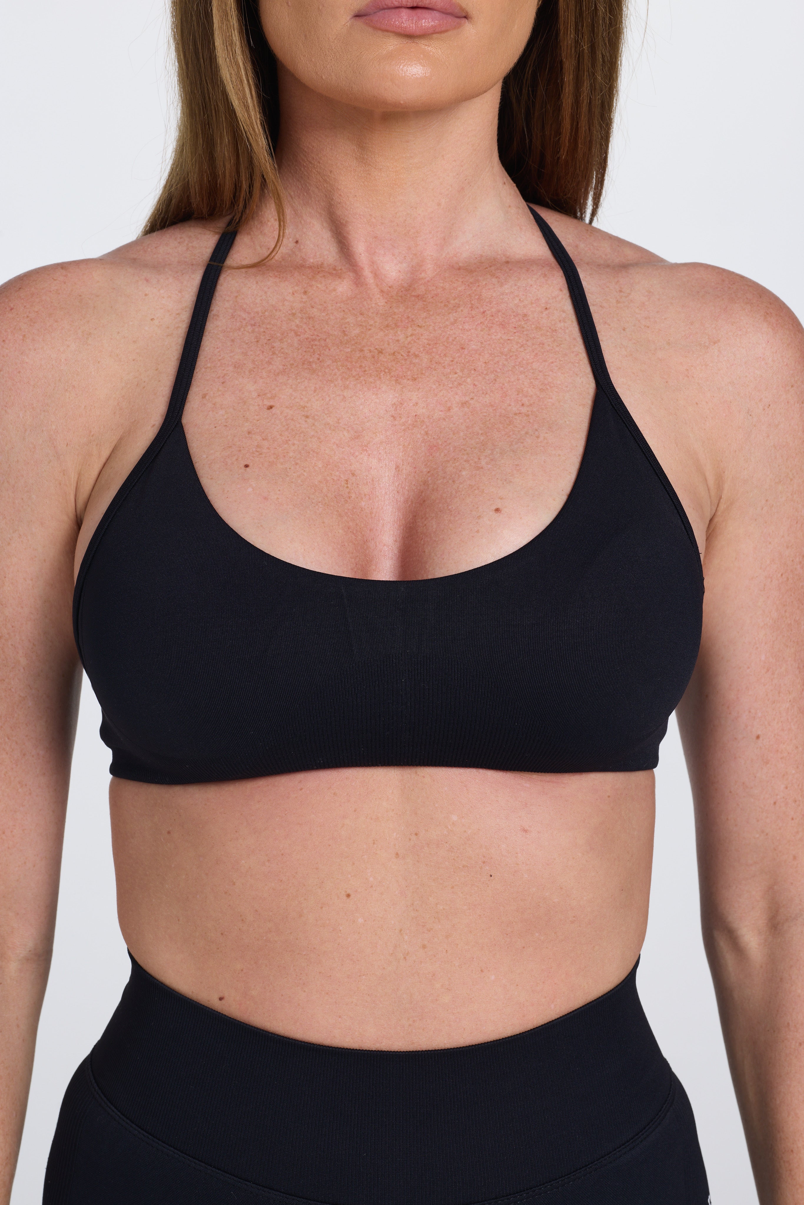 Seamless women’s gym bra with an ultra thin racerback strap design, with white PEPPAMINT branding on the back strap in black