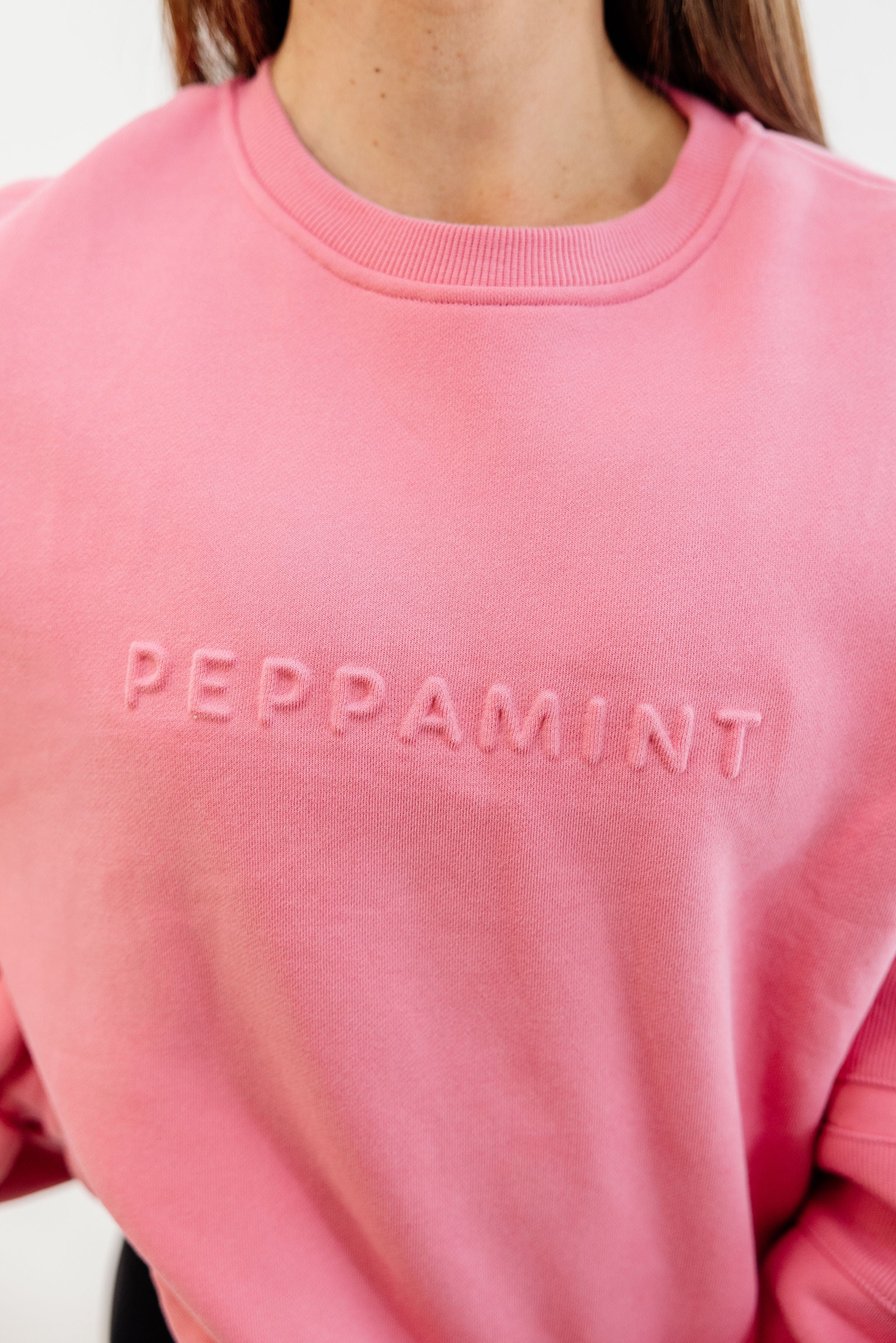 peony pink crew neck jumper with ribbed arm panels in pink with embossed logo breast cancer awareness