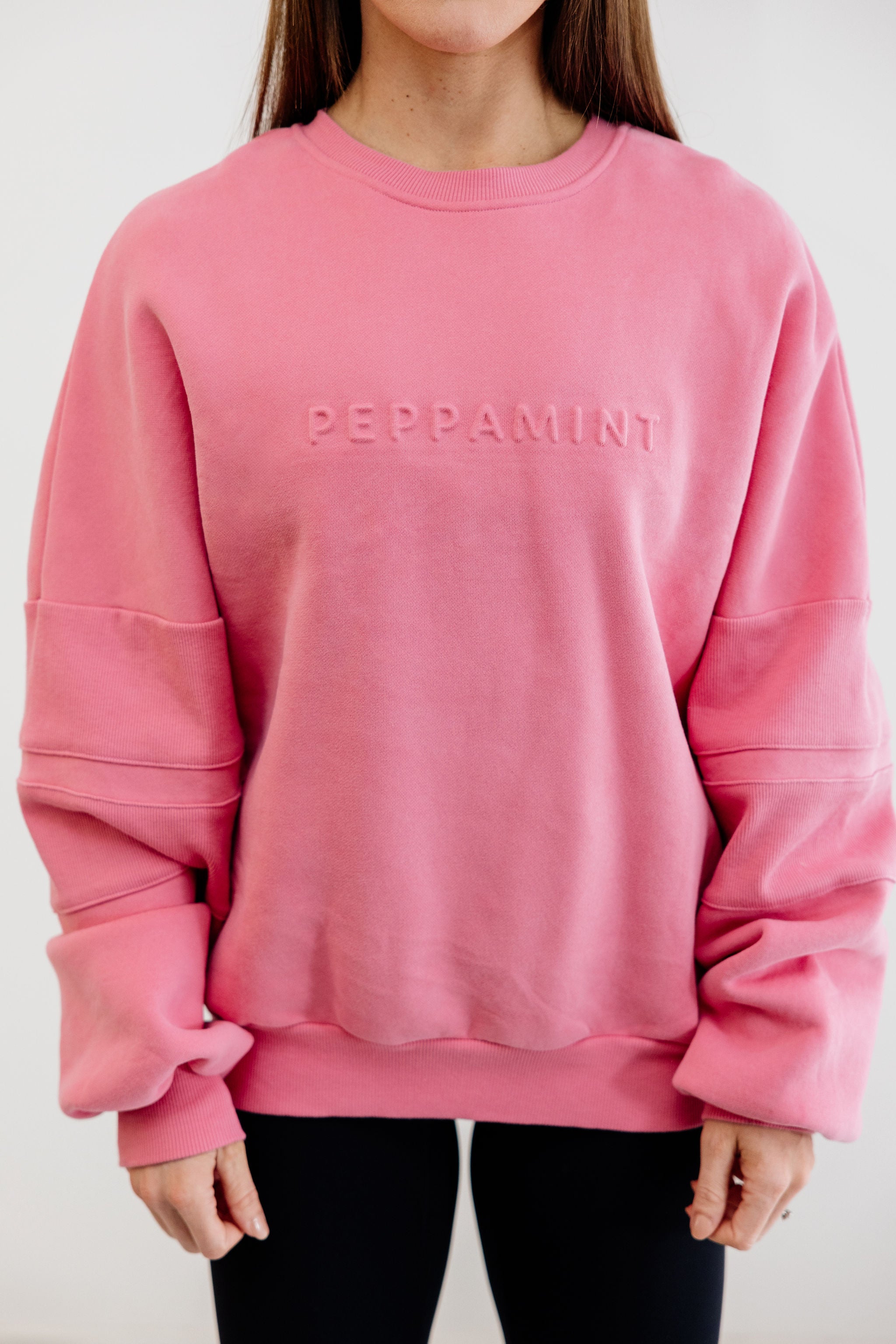 peony pink crew neck jumper with ribbed arm panels in pink with embossed logo breast cancer awareness