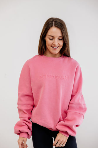 peony pink crew neck jumper with ribbed arm panels in pink with embossed logo breast cancer awareness