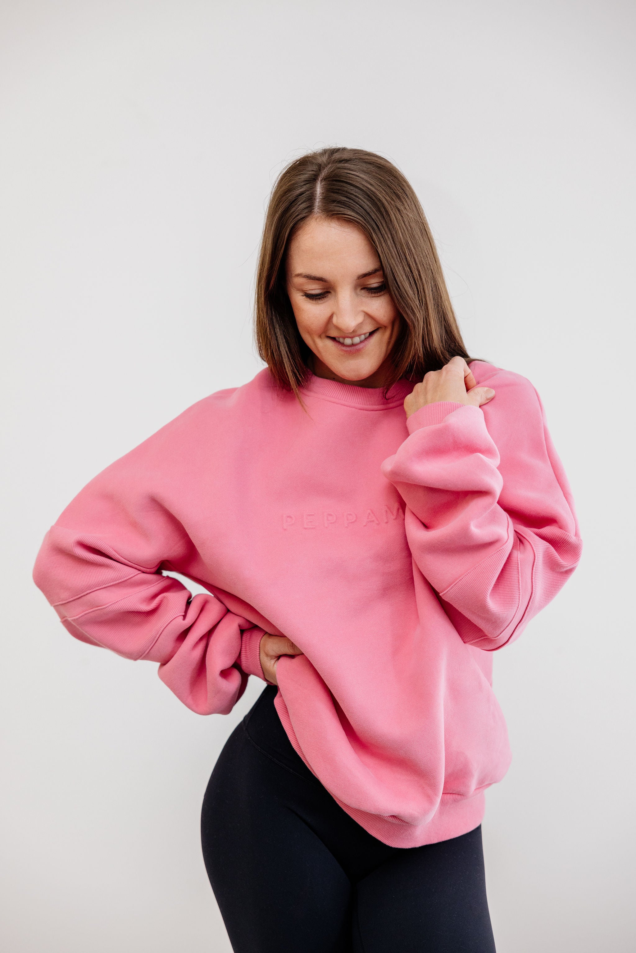 peony pink crew neck jumper with ribbed arm panels in pink with embossed logo breast cancer awareness
