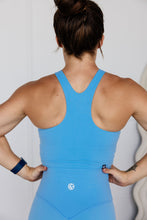 Load image into Gallery viewer, crop tank top in baby blue with build in removable bra pads, racerback design and subtle stitched logo tag
