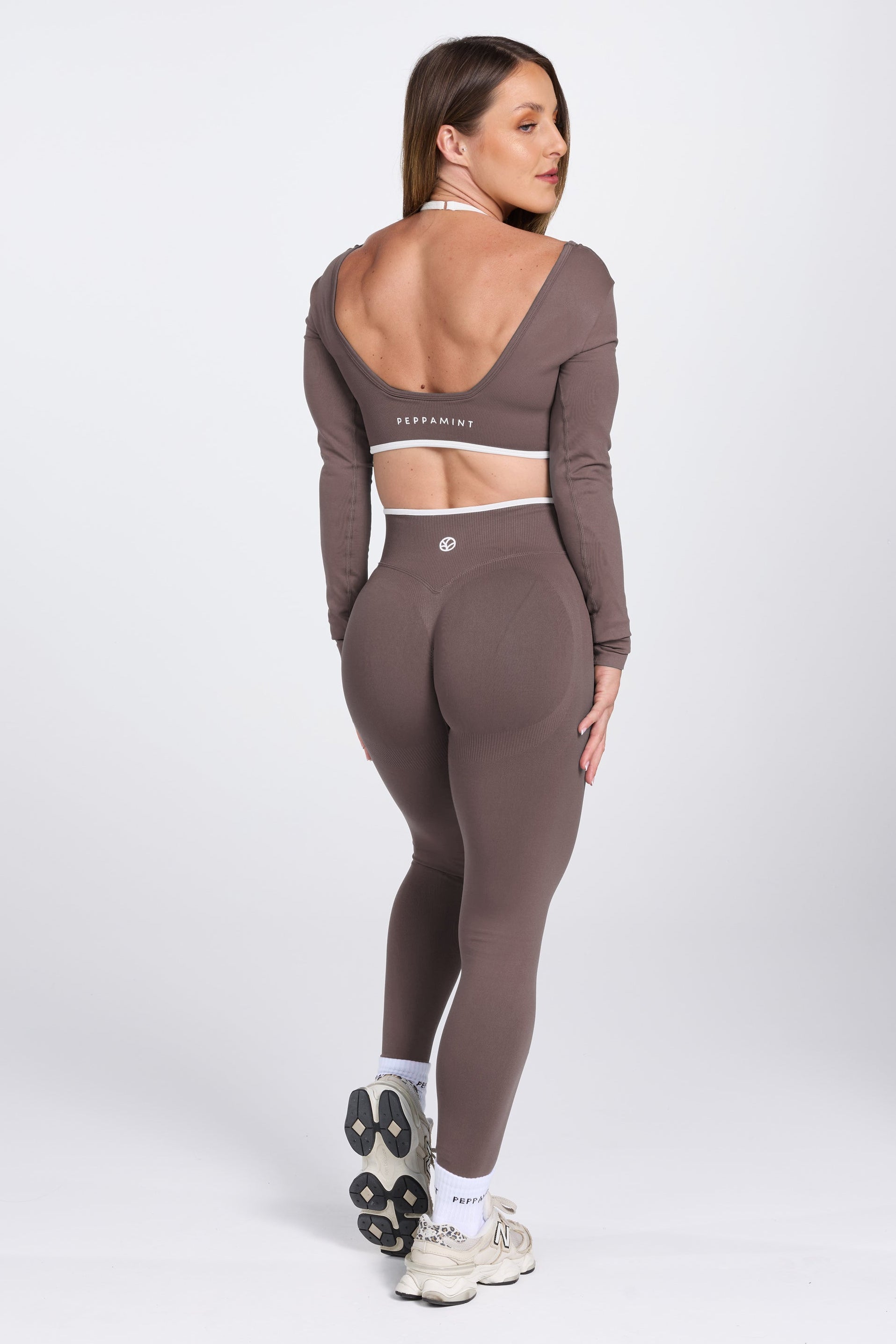 Long sleeve seamless crop top, with built in white contrasting bra, luxe white trim, and adjustable halter strap, with high waisted booty sculpting gym tights in Mocha.