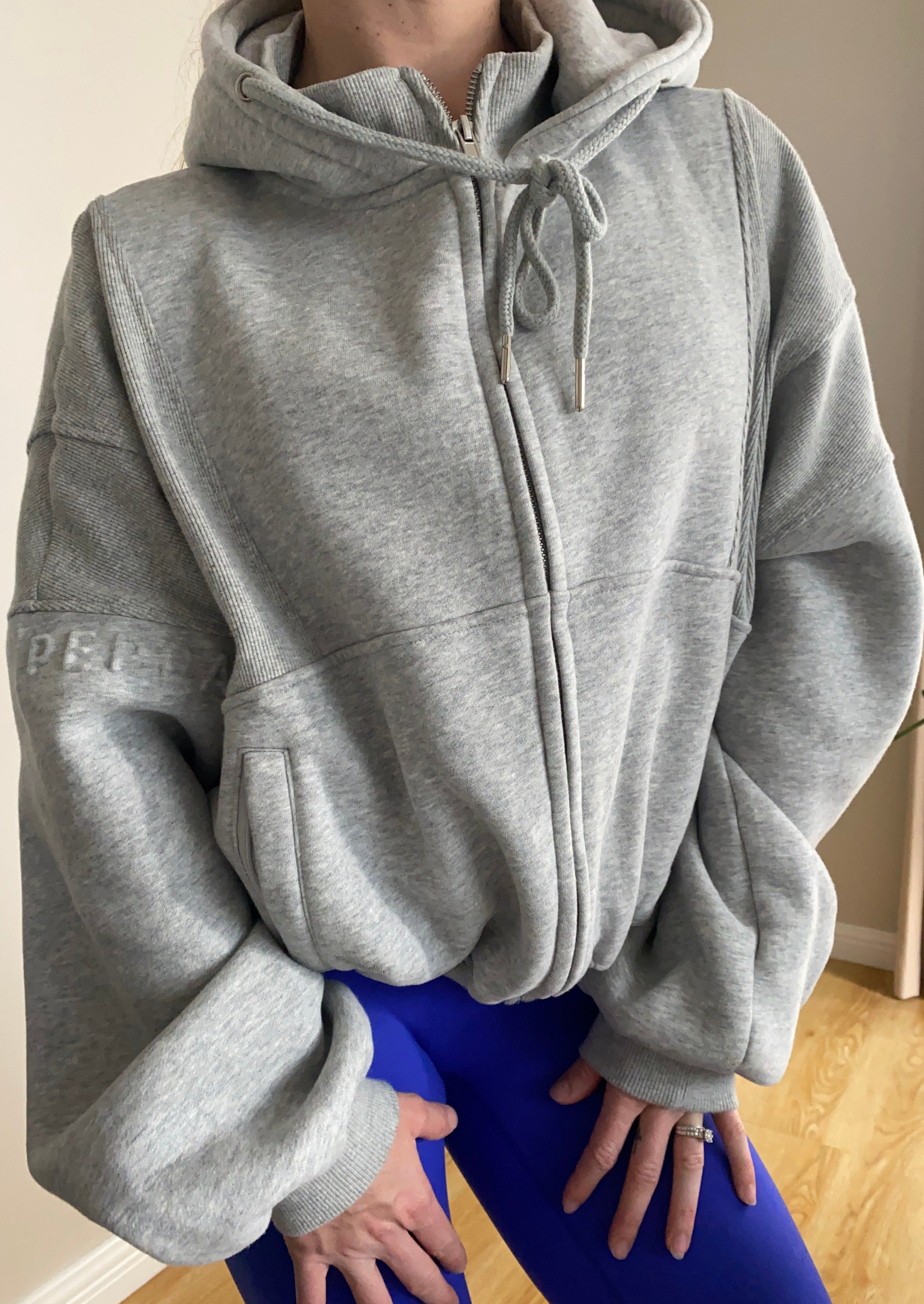 Fleece lined jacket in marl grey with full zip, hood, ribbed panels, zip pockets and embossed logo's.